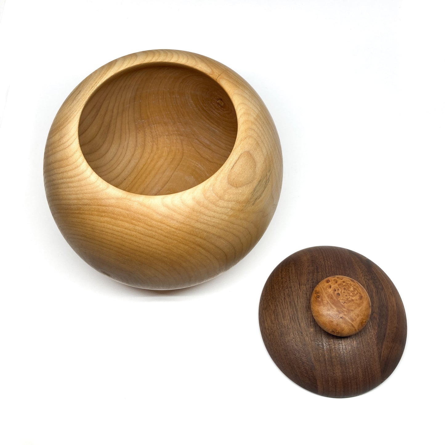 An open maple bowl with its detached dark walnut lid and burled knob next to it.