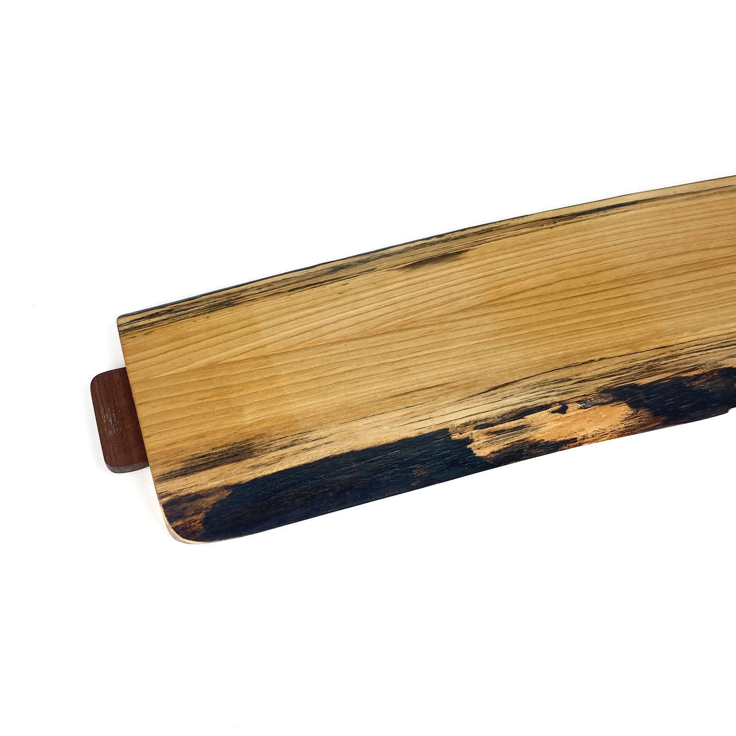 Angled close-up of a Live Edge Cherry Charcuterie Board, highlighting the natural edge and wood characteristics.