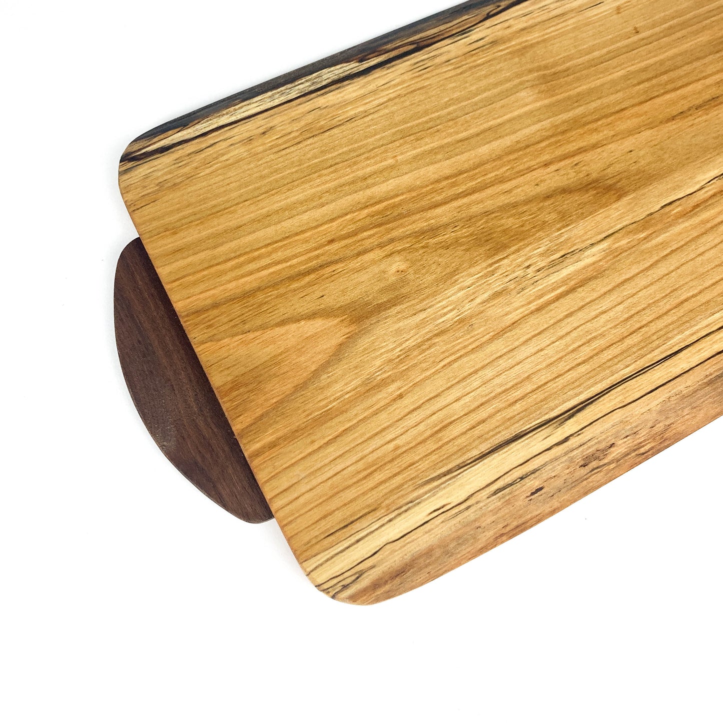 Top-down close-up of a small cherry live edge charcuterie board, focusing on the wood's unique patterns.