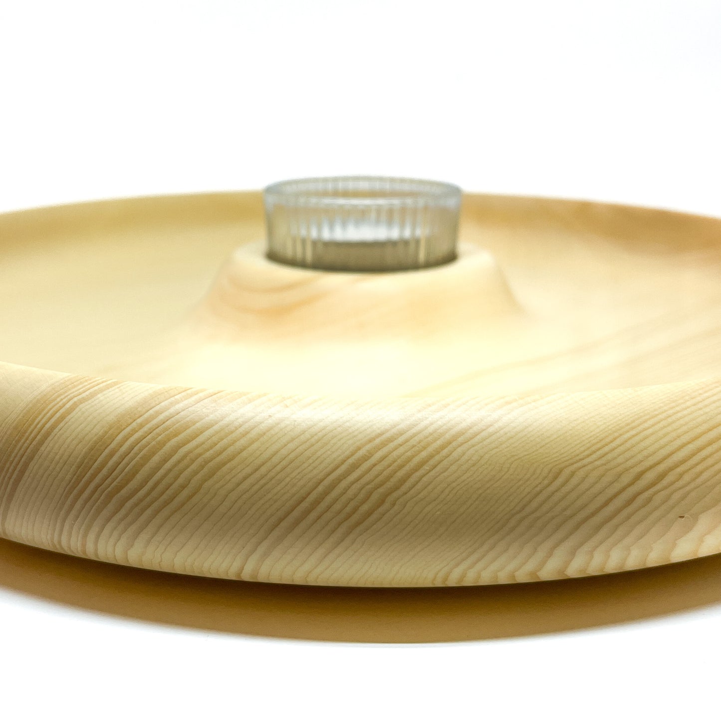 A low, angled view of a Yellow Cedar Candle Tray #2 with a glass votive in the center.