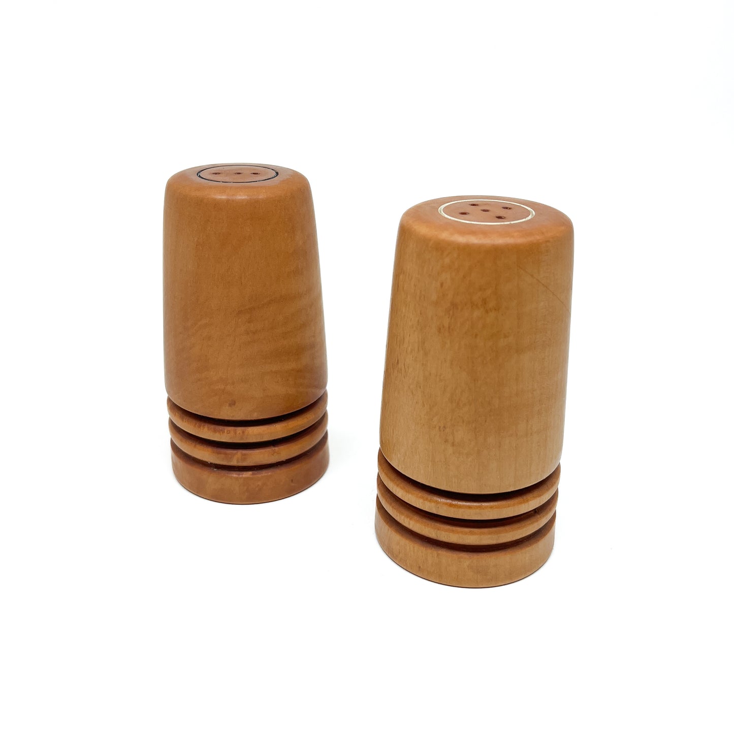 A pair of wooden Flared Arbutus Salt & Pepper shakers standing upright, showing their tops with shaker holes.