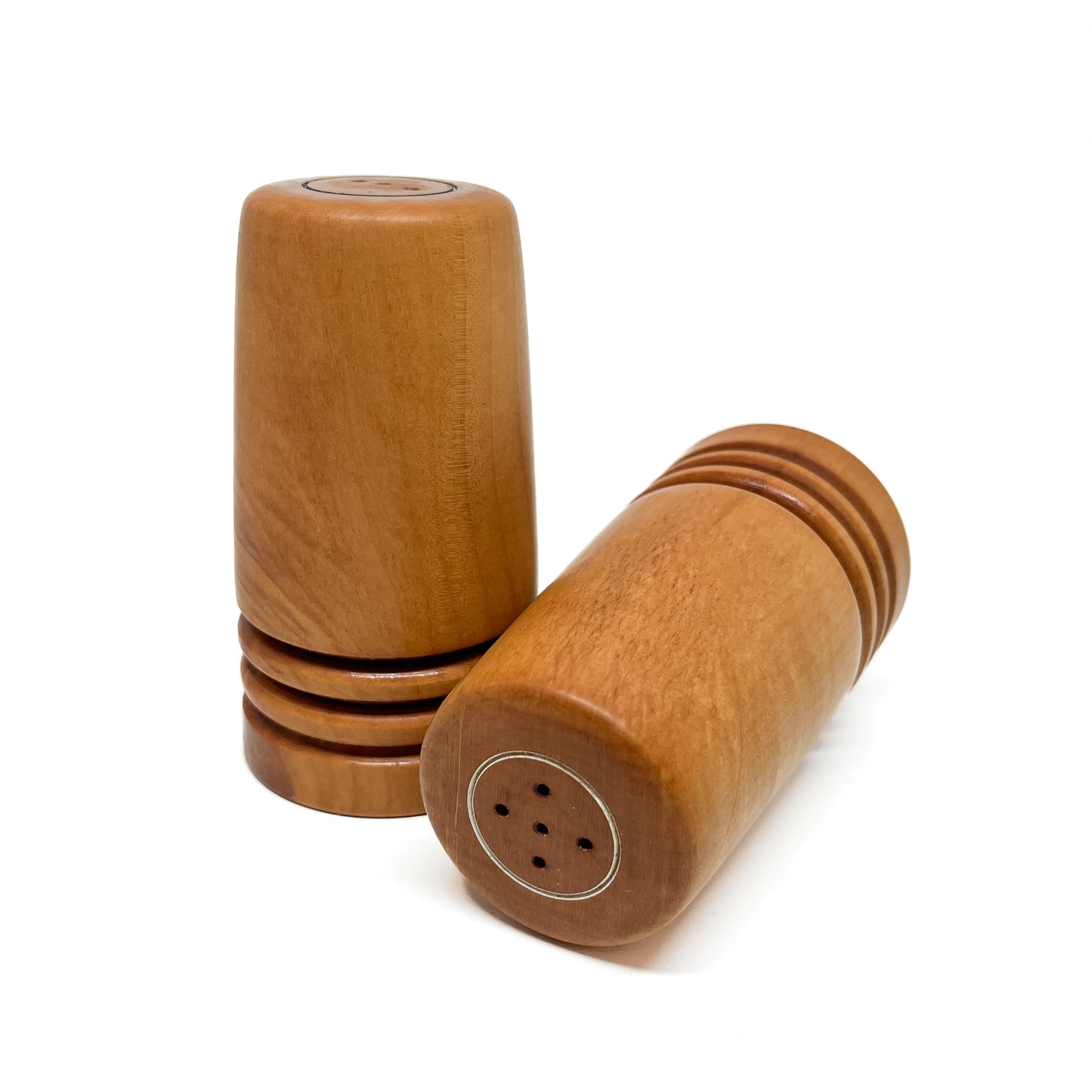 One wooden Flared Arbutus Salt & Pepper shaker standing and another lying down, showcasing the holes.