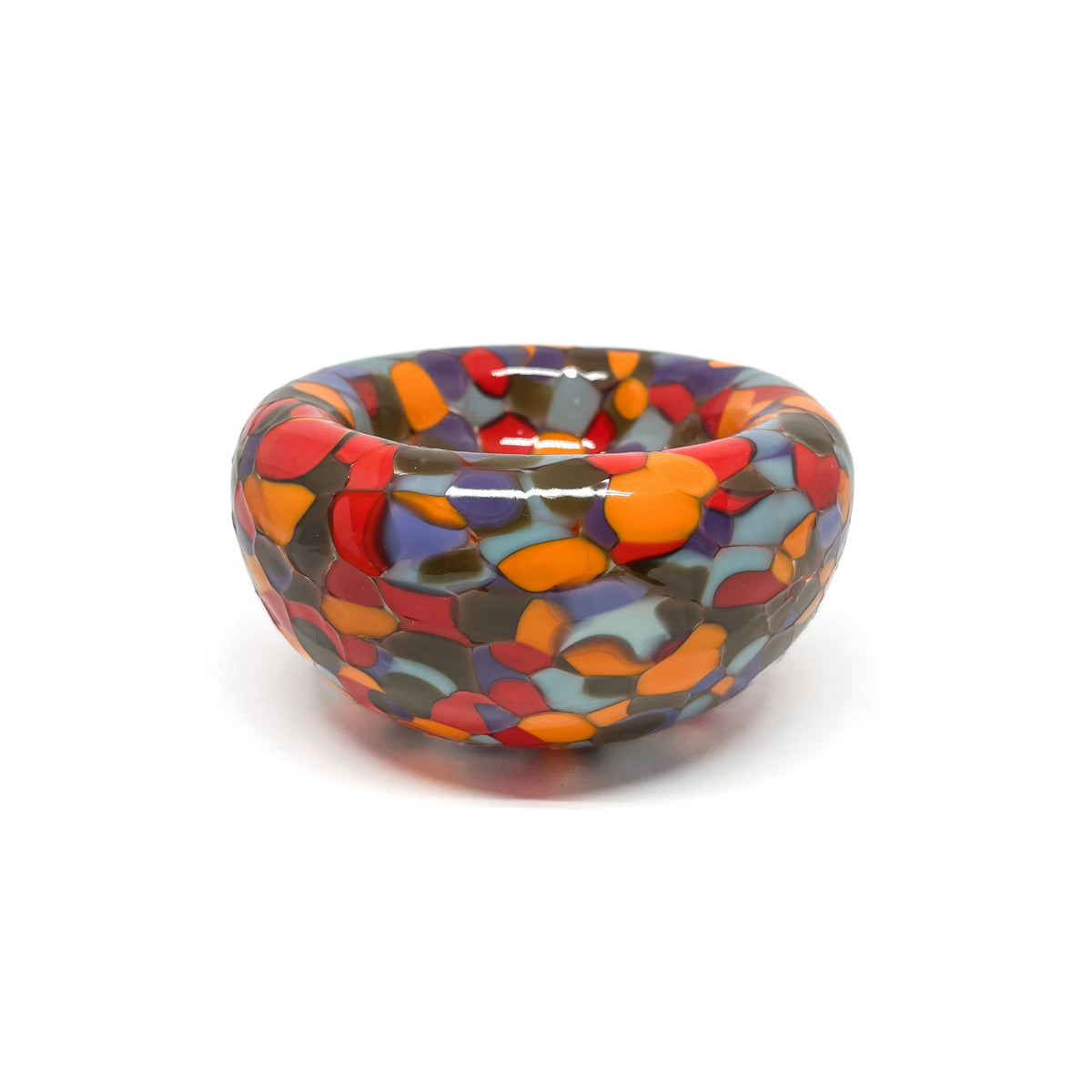 Side view of a red-multicolor Blotched Nest Bowl with dense, glossy scattered glass spots.