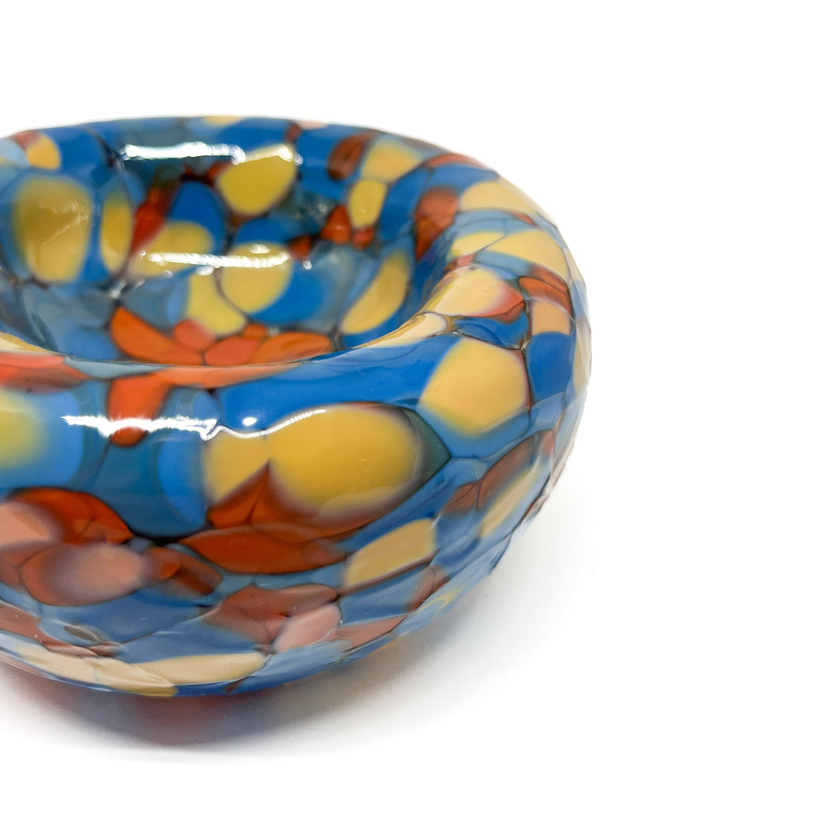 Close-up detail of the blue-orange Blotched Nest Bowl showing bold, glossy surface pattern.