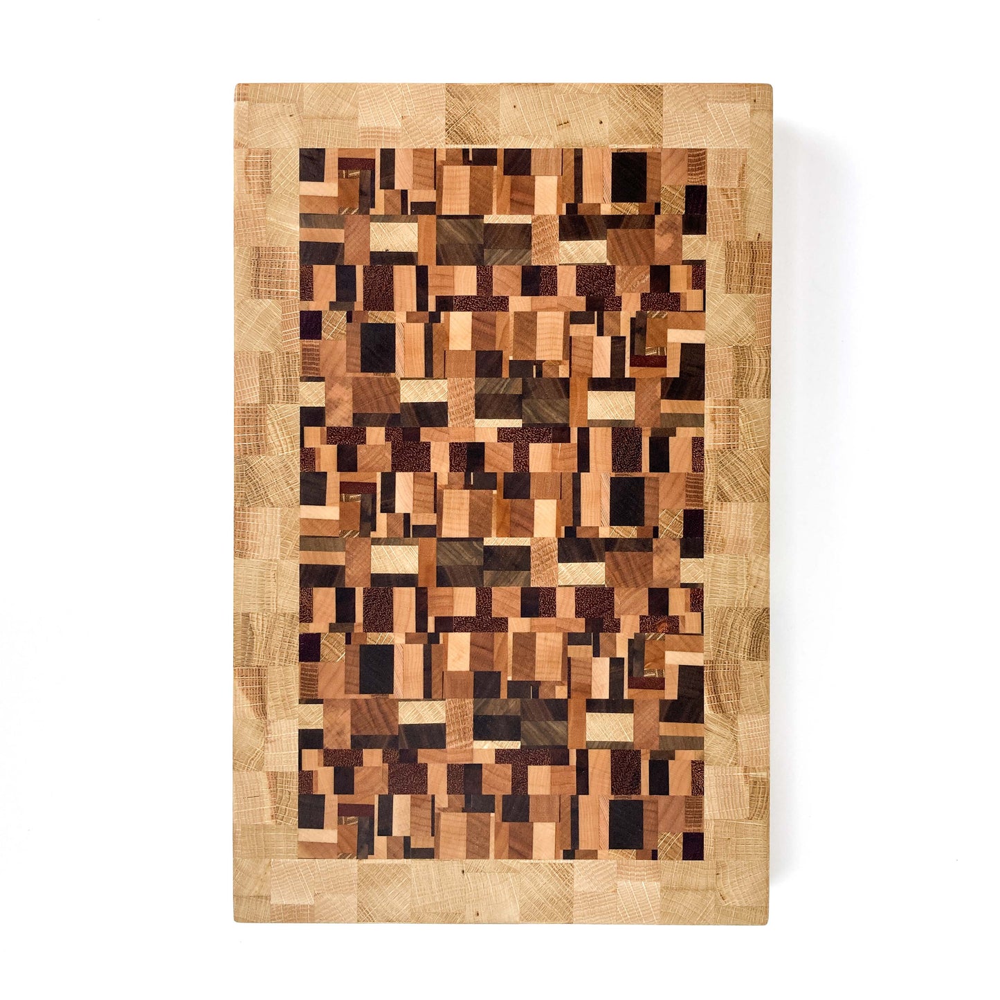An overhead view of an end grain cutting board featuring a chaotic, rectangular wood block pattern.