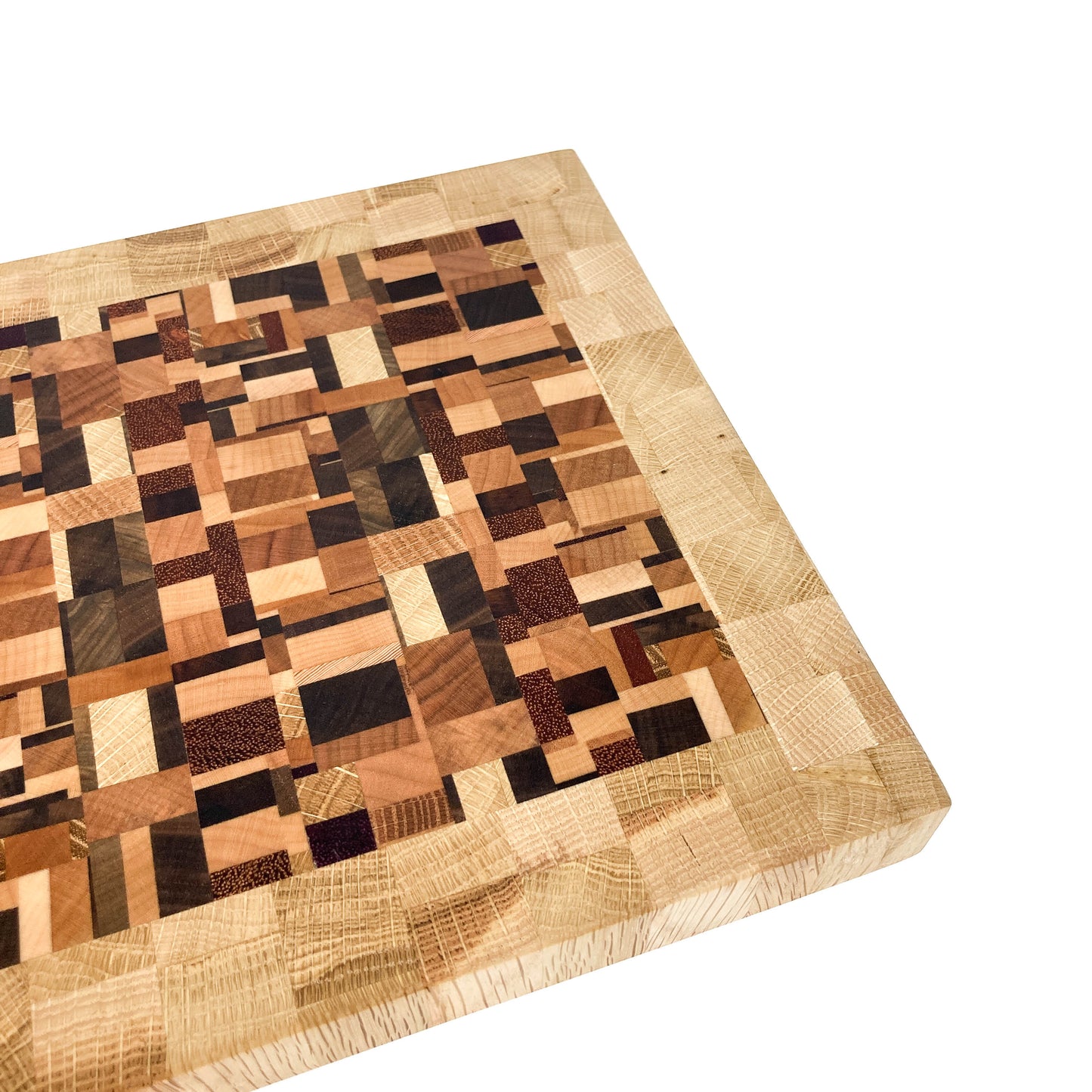 A close-up, angled view of an end grain cutting board, highlighting its varied wood block pattern.