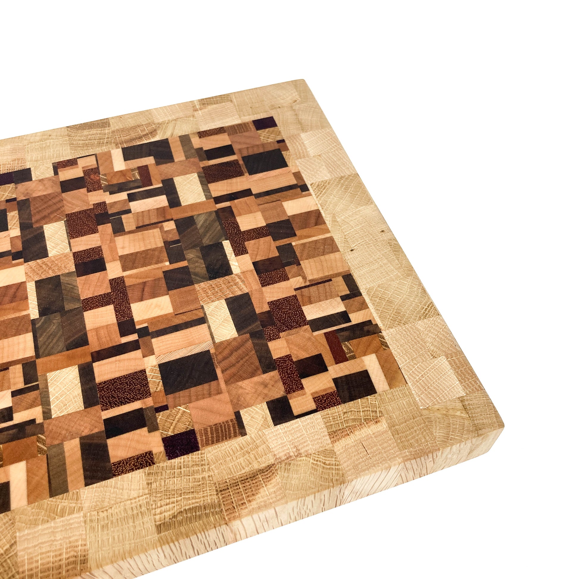 A close-up, angled view of an end grain cutting board, highlighting its varied wood block pattern.