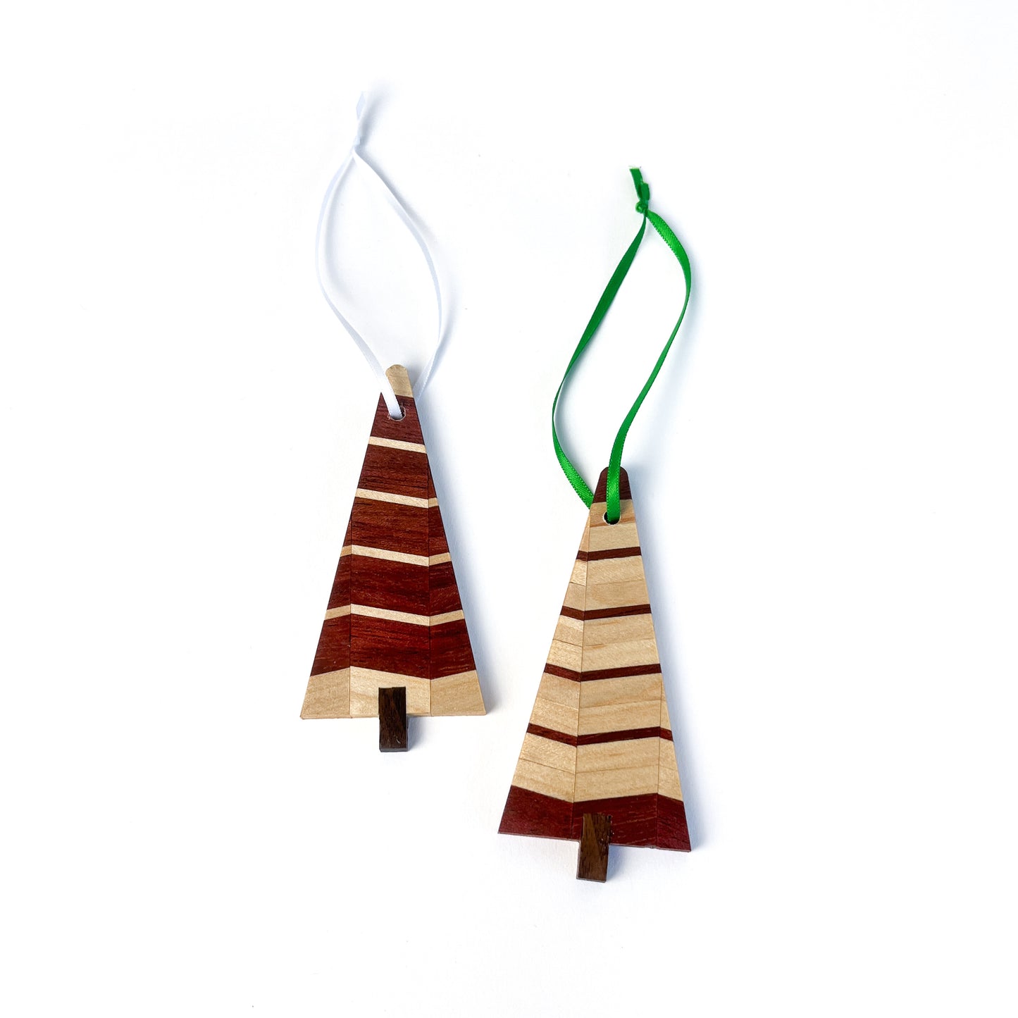 Two striped wooden Christmas tree ornaments. One has a white ribbon, the other has a green ribbon.