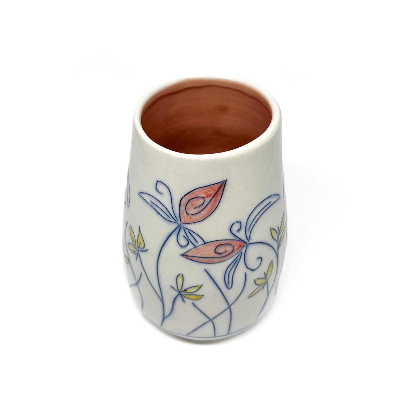 A white ceramic vase with a light brown inner glaze features blue outlined flowers and stems with reddish-orange and yellow petal accents.