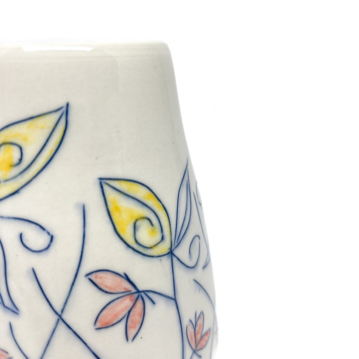 Close-up of a white ceramic vase showing hand-painted blue floral outlines with yellow and reddish-orange petal details.