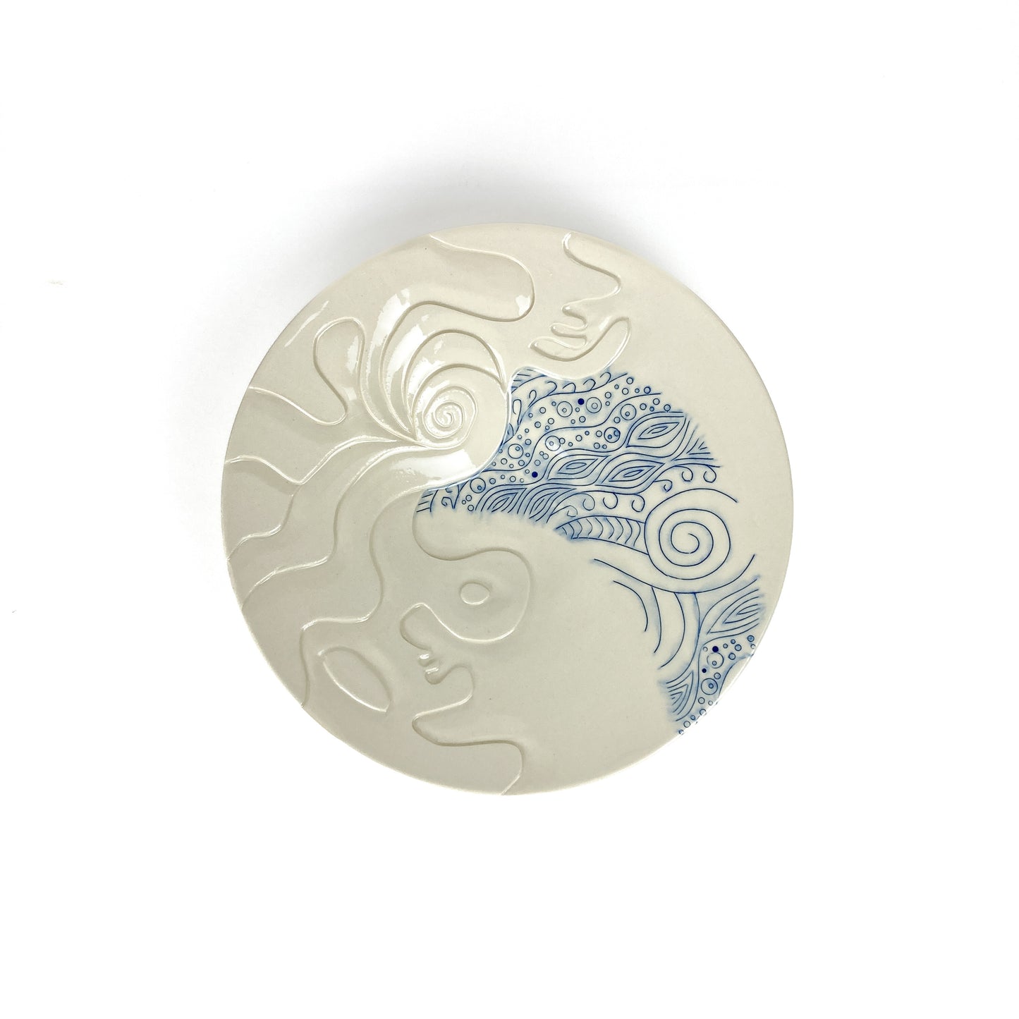 Wide ceramic plate featuring abstract blue designs and textured white patterns.