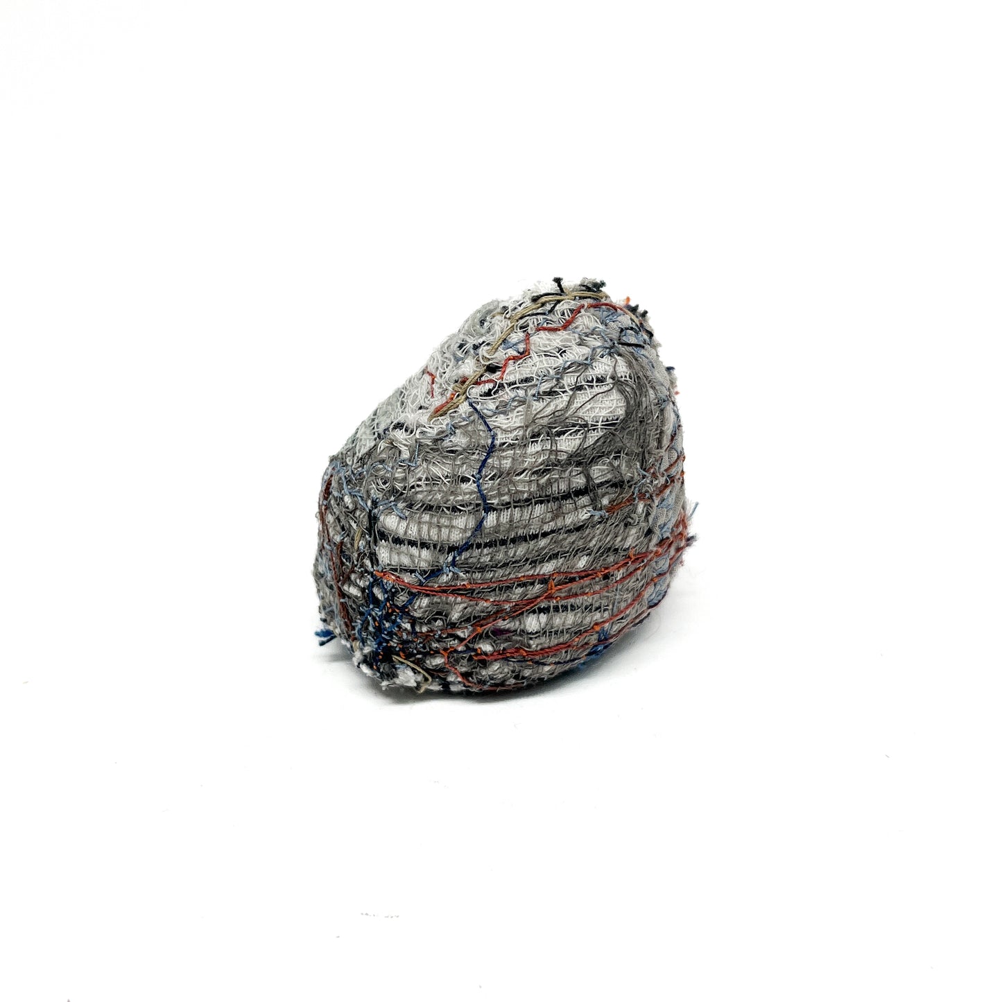 Embroidered Rock by Jane Kenyon: Round textured textile art resembling a rock, with dominant gray and white thread stitching and hints of color.
