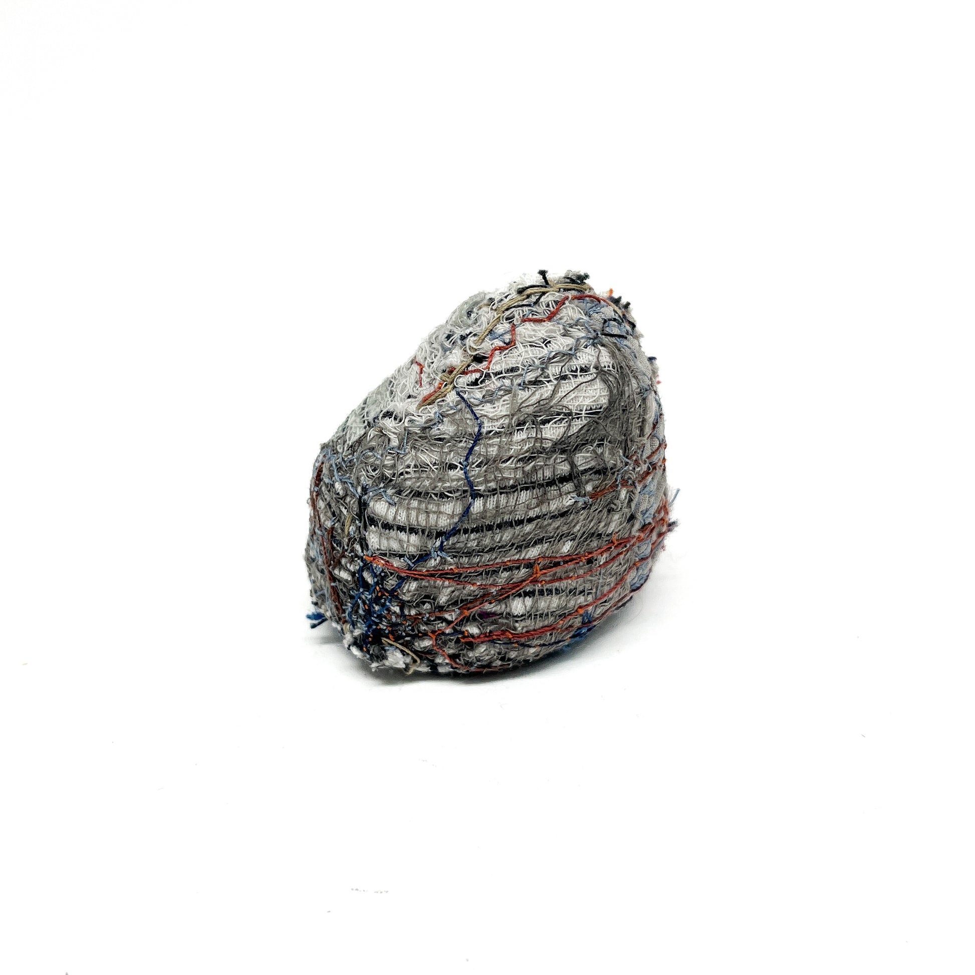 Embroidered Rock by Jane Kenyon: Round textured textile art resembling a rock, with dominant gray and white thread stitching and hints of color.
