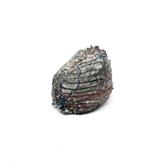 Embroidered Rock by Jane Kenyon: Round textured textile art resembling a rock, with dominant gray and white thread stitching and hints of color.