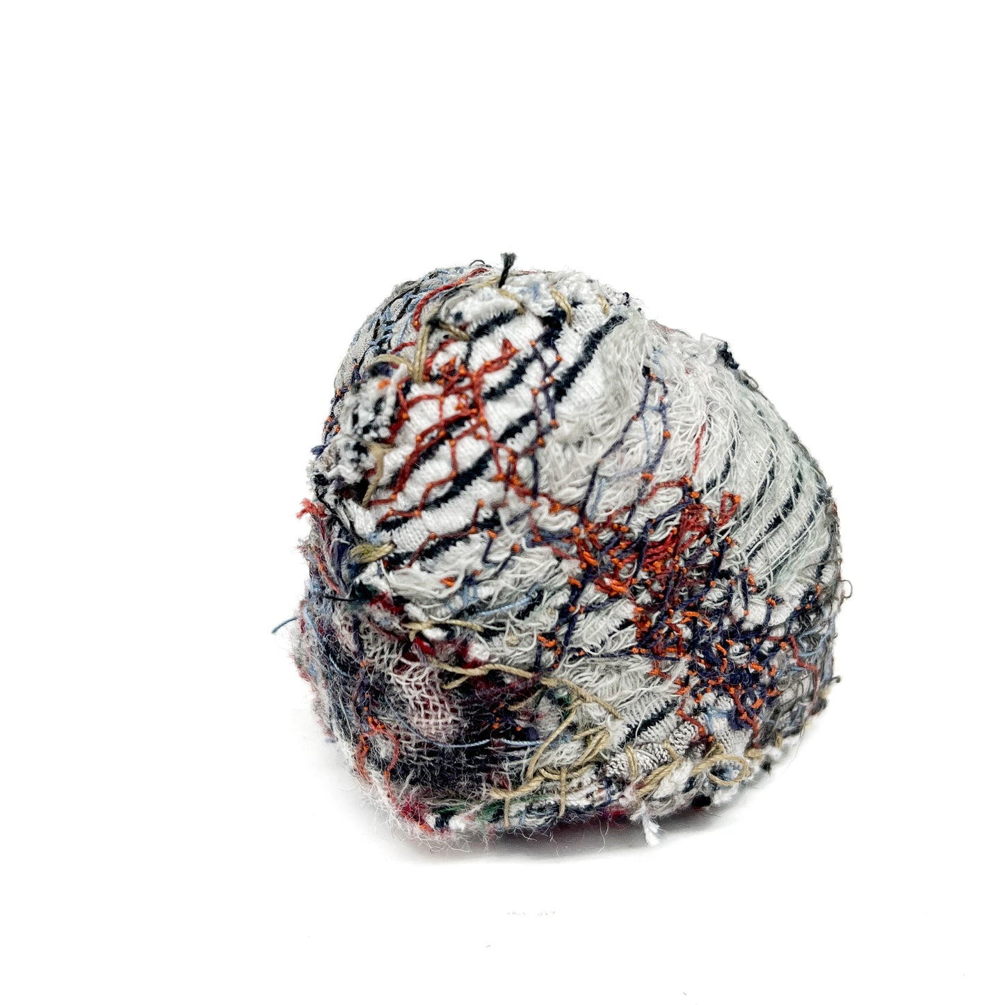 Embroidered Rock by Jane Kenyon: Round textured textile art resembling a rock, with layered stitching in white, black, orange, and blue threads.