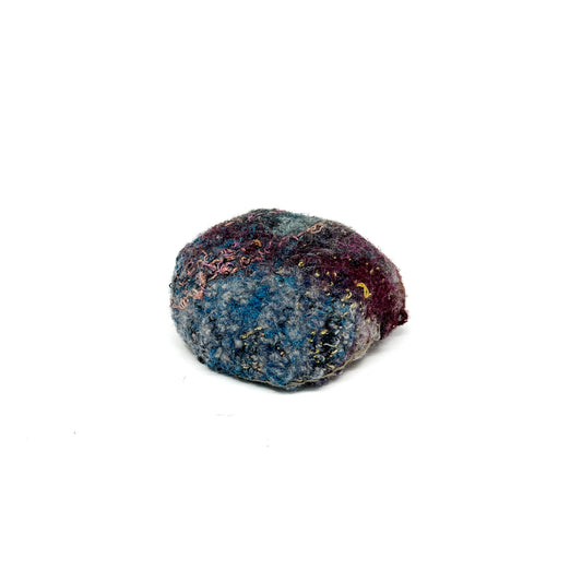 Embroidered Rock by Jane Kenyon: Round textured textile art resembling a rock, with rich blue, purple, and gold thread stitching.