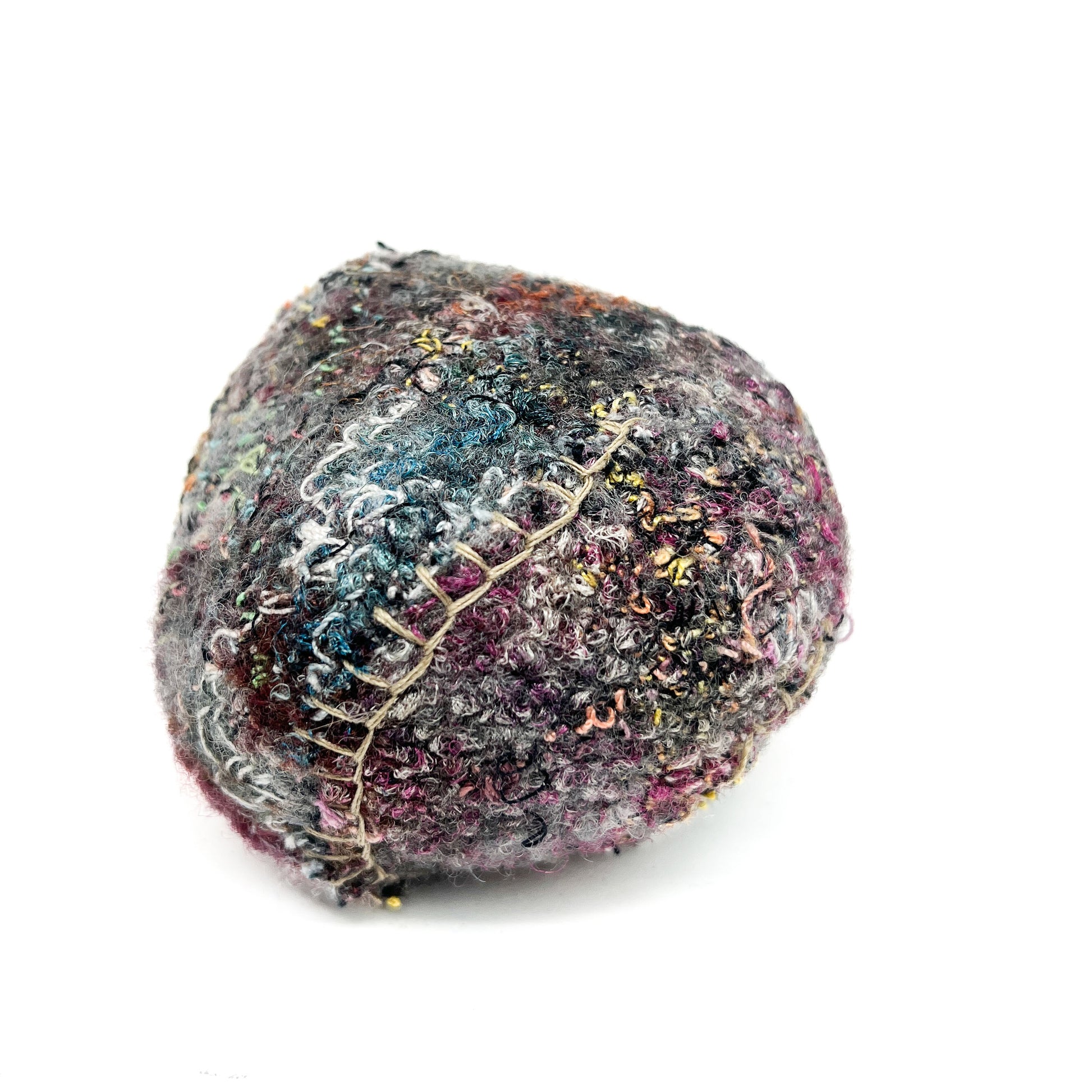 Embroidered Rock: Round textured textile art resembling a rock, with dense and varied colorful thread stitching.