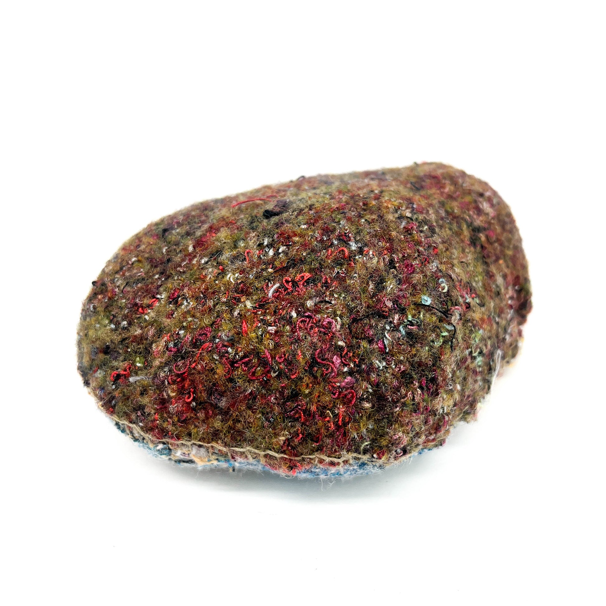A rock covered in a thick, textured layer of colorful and densely packed stitching and embroidery.
