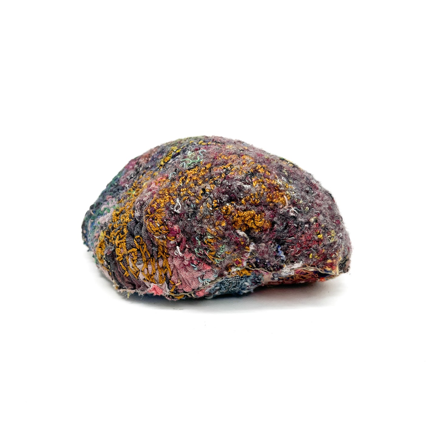 A stone by Jane Kenyon, features a textured surface of colorful, dense embroidery and stitching.