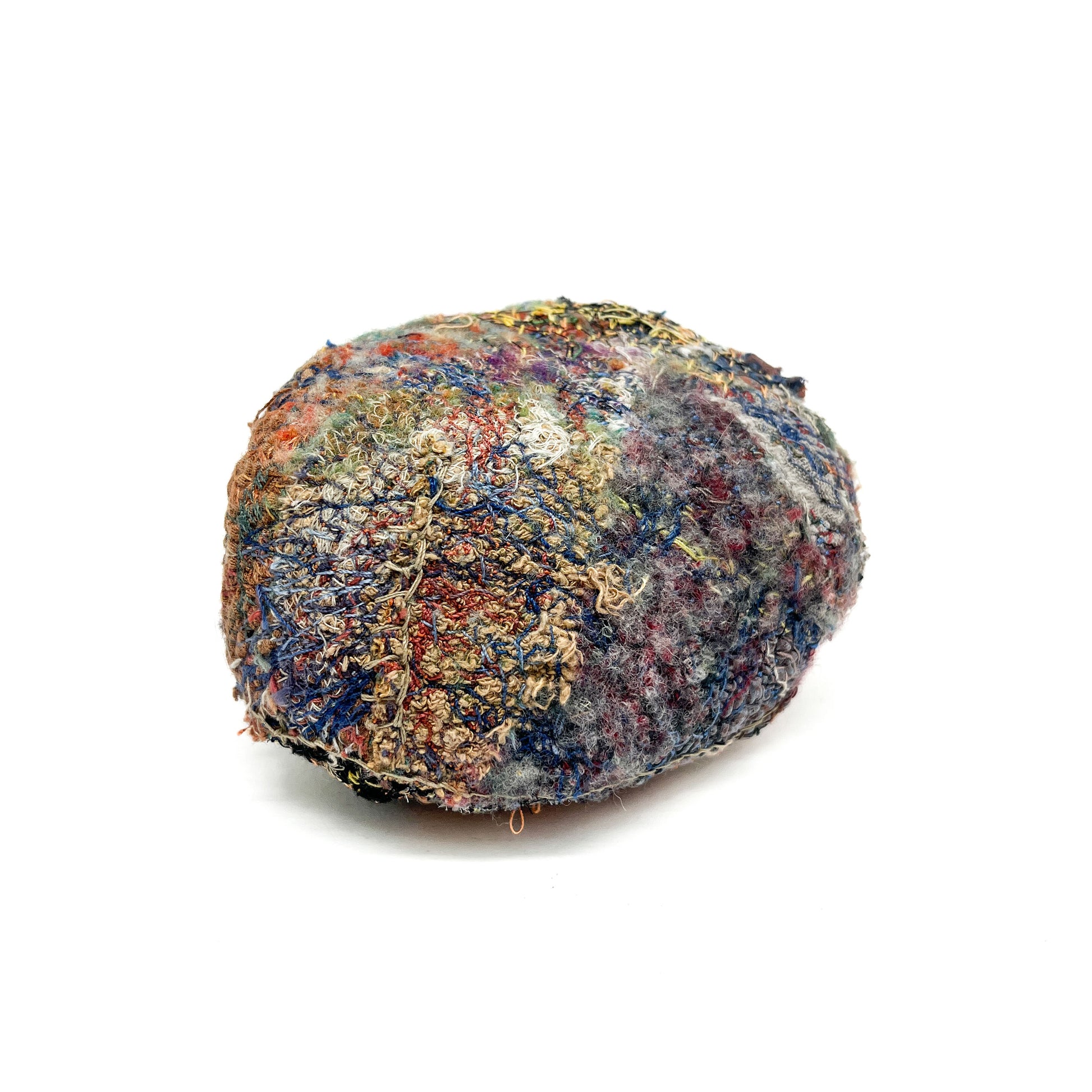 A stone by Jane Kenyon, showcases a textured surface of colorful, intricate embroidery and stitching.