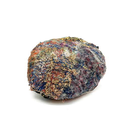 A stone by Jane Kenyon, showcases a textured surface of colorful, intricate embroidery and stitching.