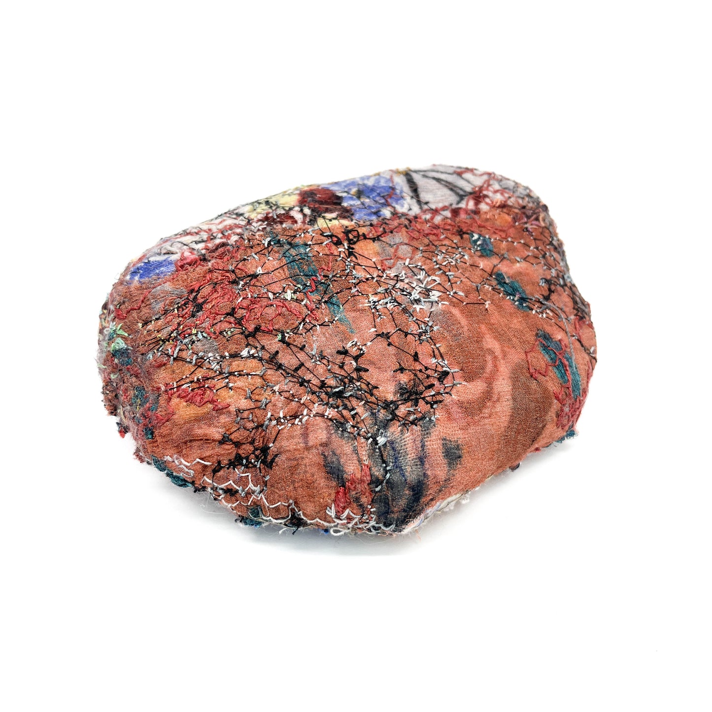 Irregularly shaped object with layered textile textures and intricate stitching details.