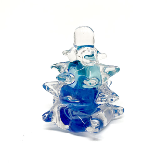 A clear glass Christmas tree with blue swirls.