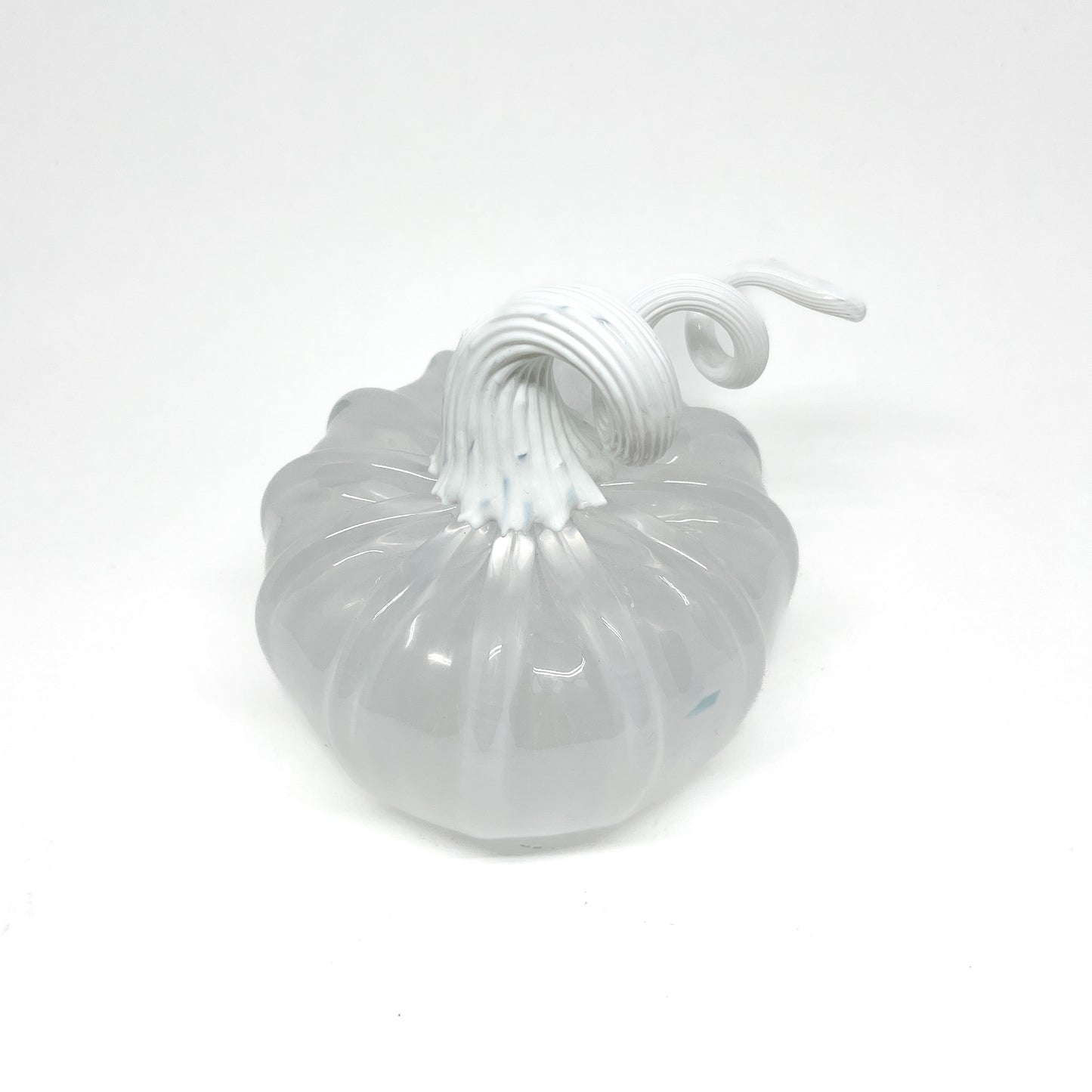 A white glass pumpkin with a curled, white glass stem.