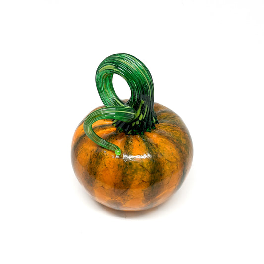 A glass pumpkin with orange and green stripes, featuring a curled green stem.