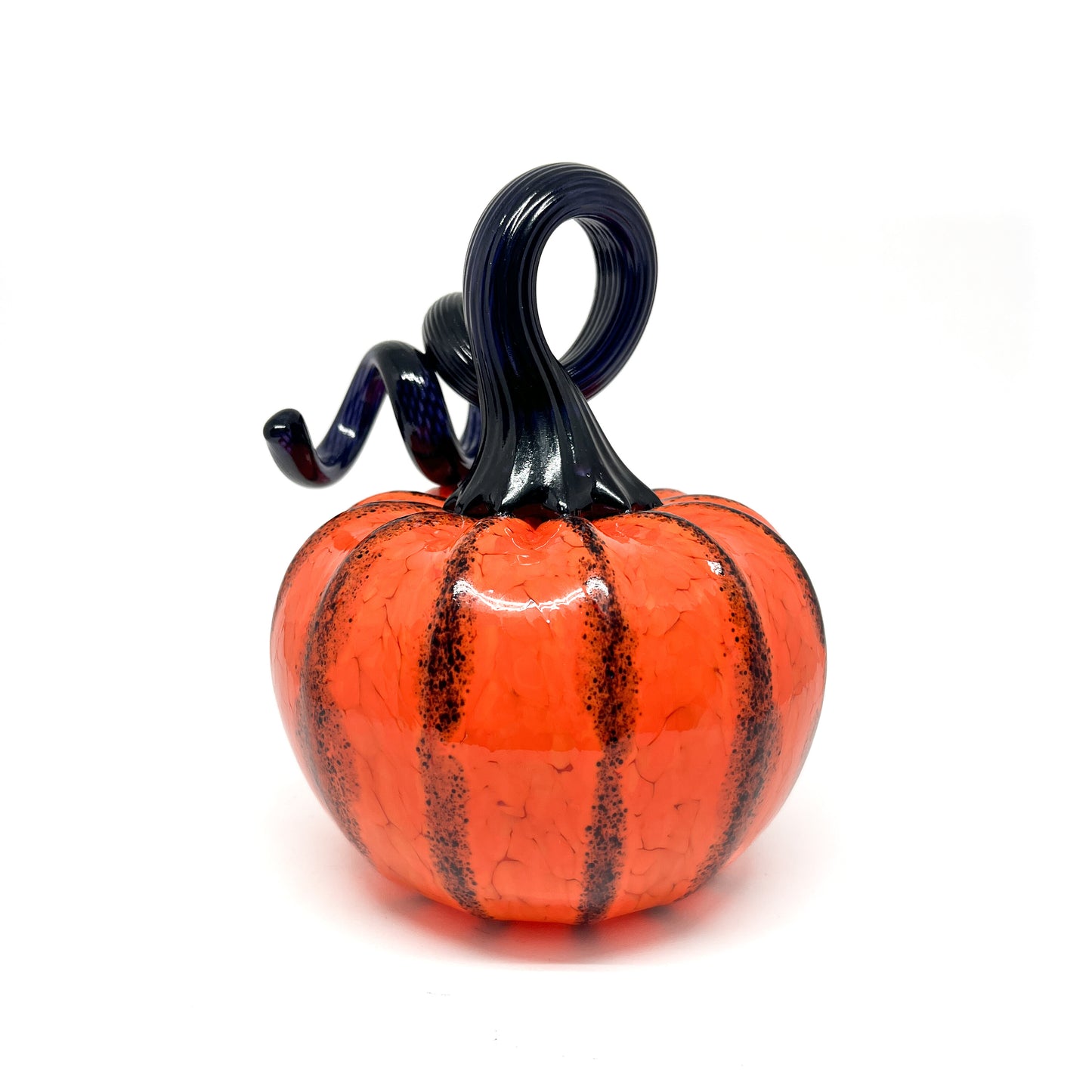 An orange glass pumpkin with black stripes and a curled, dark blue glass stem.