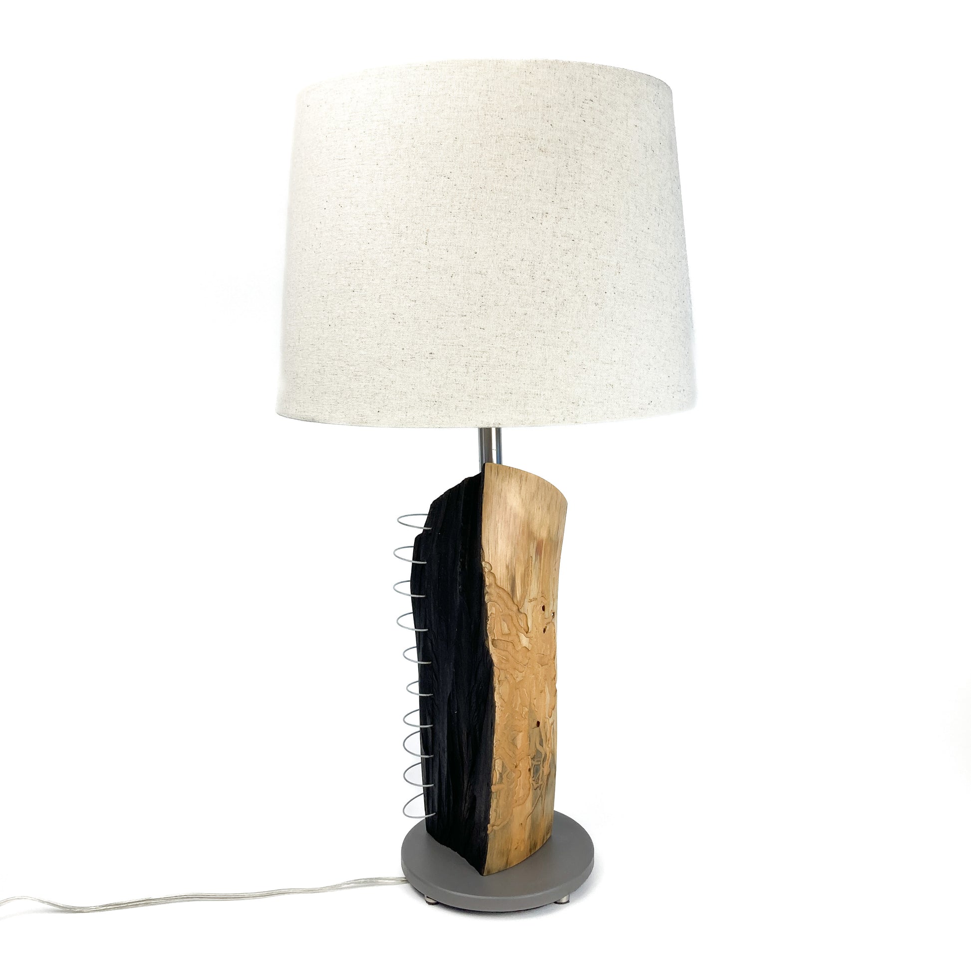 Rustic table lamp with a wood and metal base, featuring a spiral detail, a round metal stand, and a fabric lampshade.