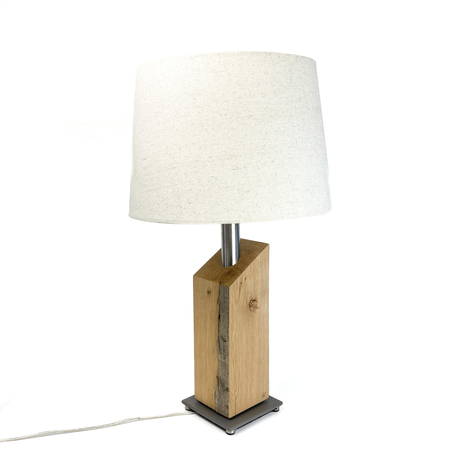 Table lamp with white shade, wood base, and gray square base.