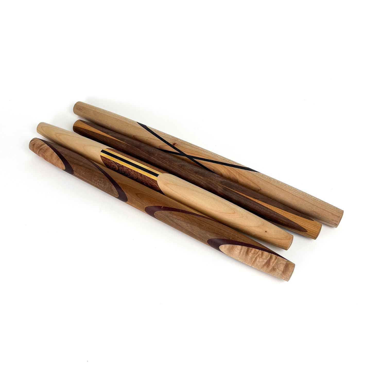 Five wooden rolling pins with various wood grains and decorative accents, arranged diagonally. The rolling pins have a smooth, polished finish.