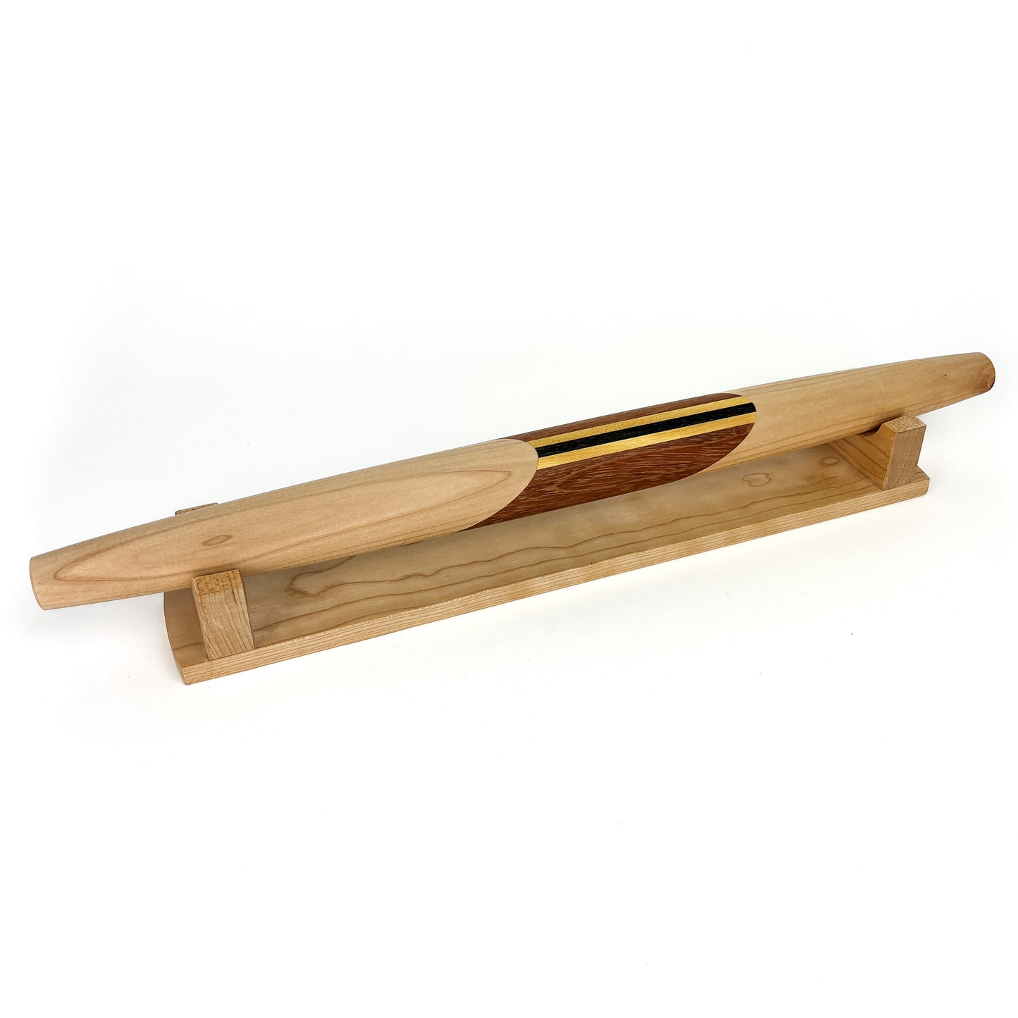 A wooden French rolling pin with a decorative striped inlay, resting on a wooden stand. The pin has a smooth, polished finish.