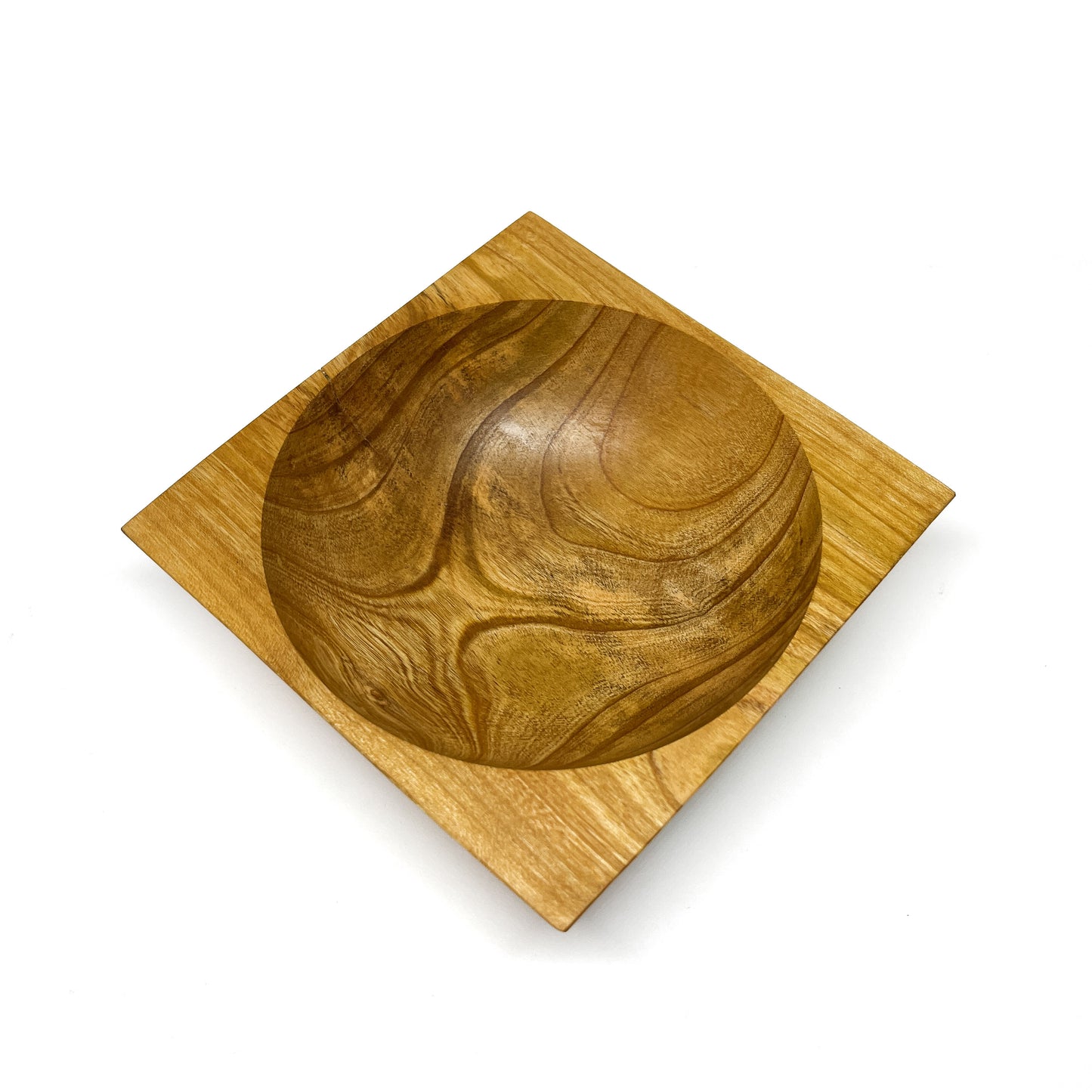 A round wooden bowl with visible grain, set within a square wooden base and viewed from above. The bowl has a smooth, carved interior.