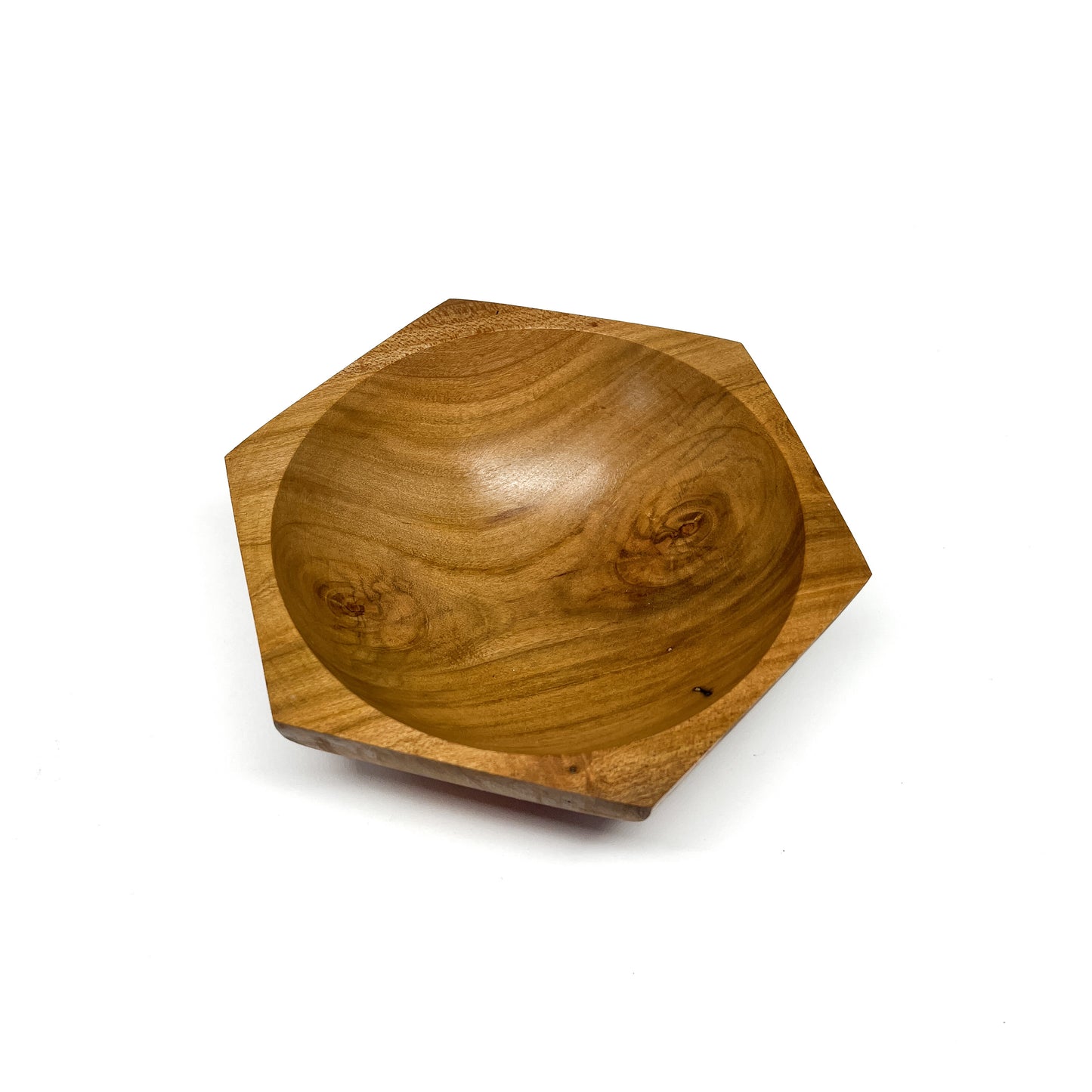 A six-sided wooden bowl with visible grain and a smooth, carved interior. The bowl has a shallow depth.