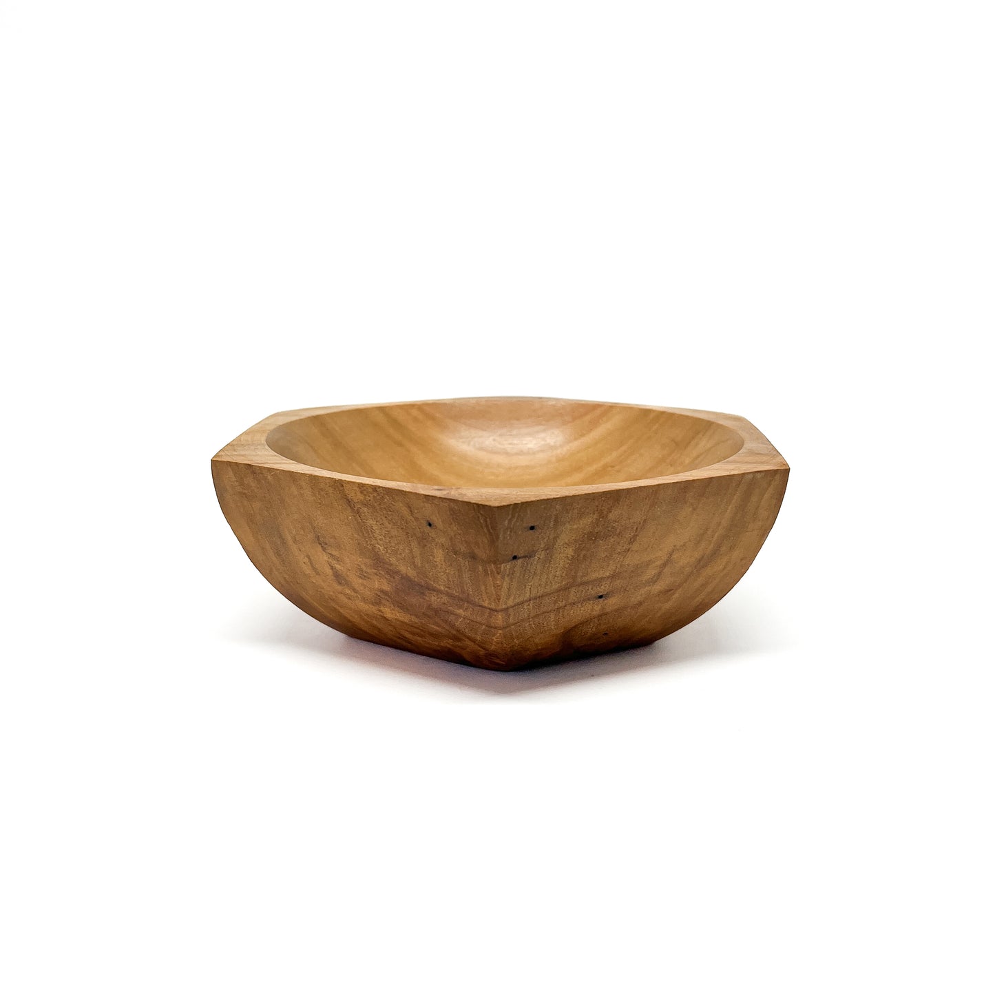 A six-sided wooden bowl with visible grain and a smooth, carved interior. The bowl has a shallow depth.