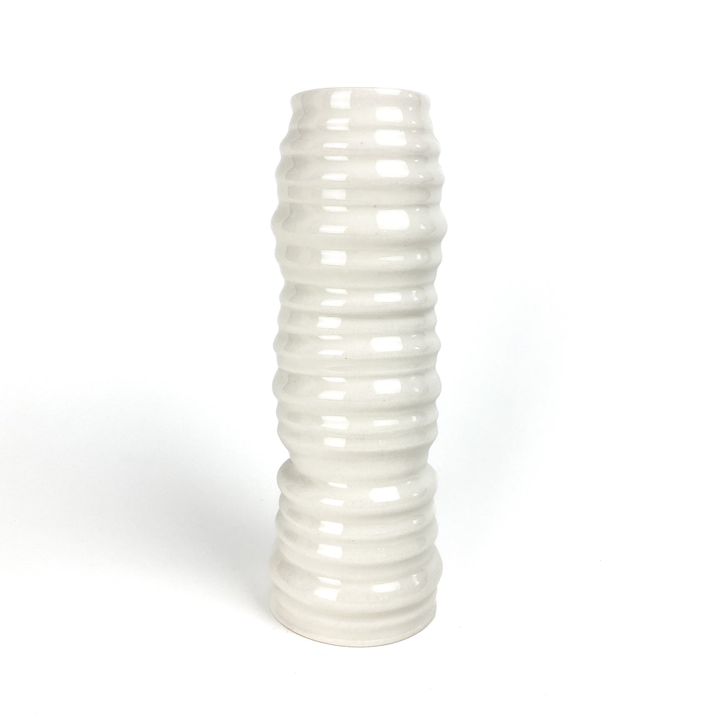 A tall, cylindrical ceramic vase with evenly spaced horizontal ridges and a slightly narrower middle section.