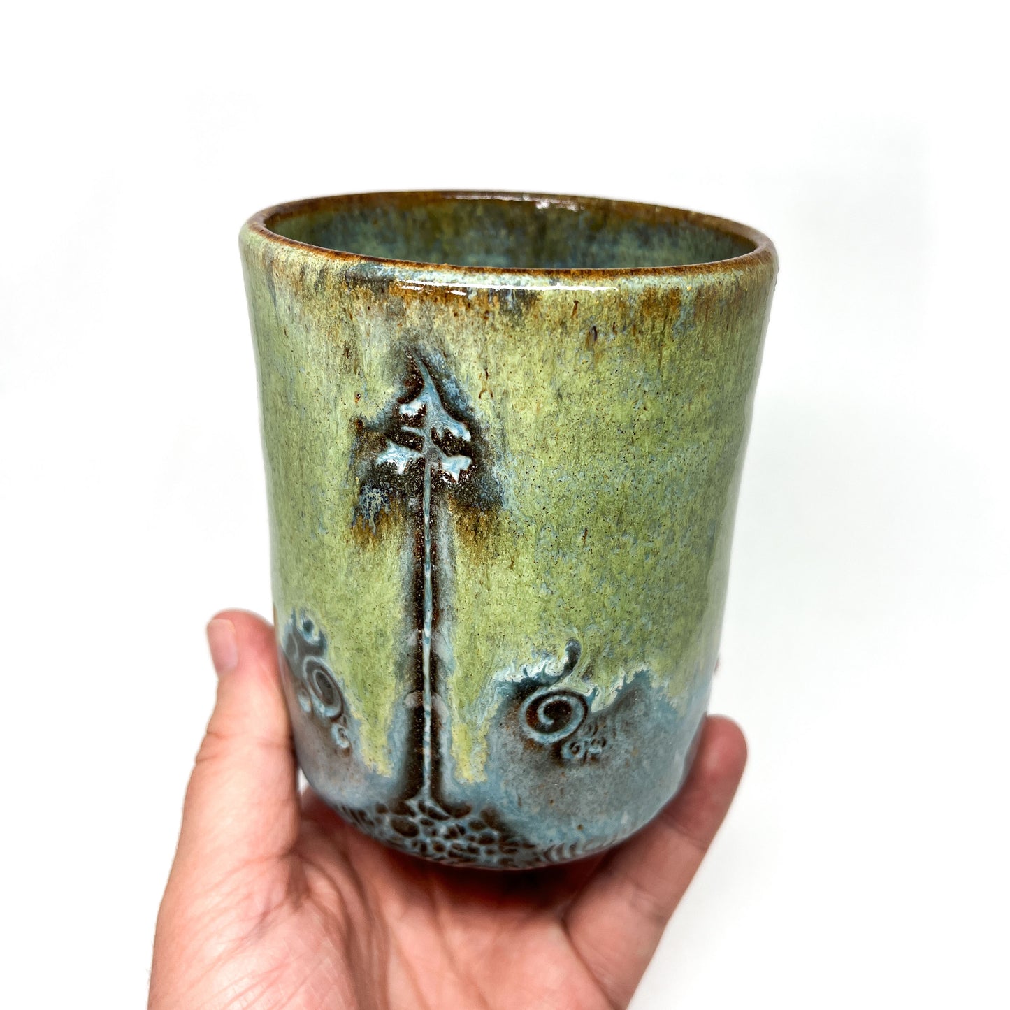 One glazed terracotta cup with tree design.