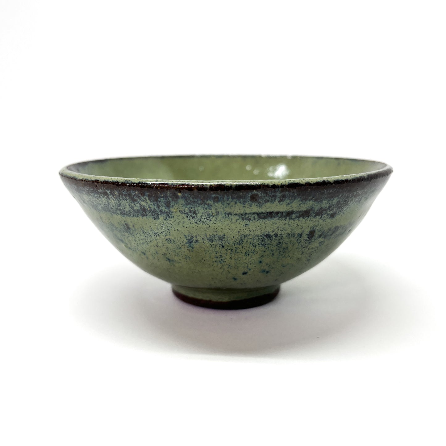 Green glazed terracotta bowl with dark rim.