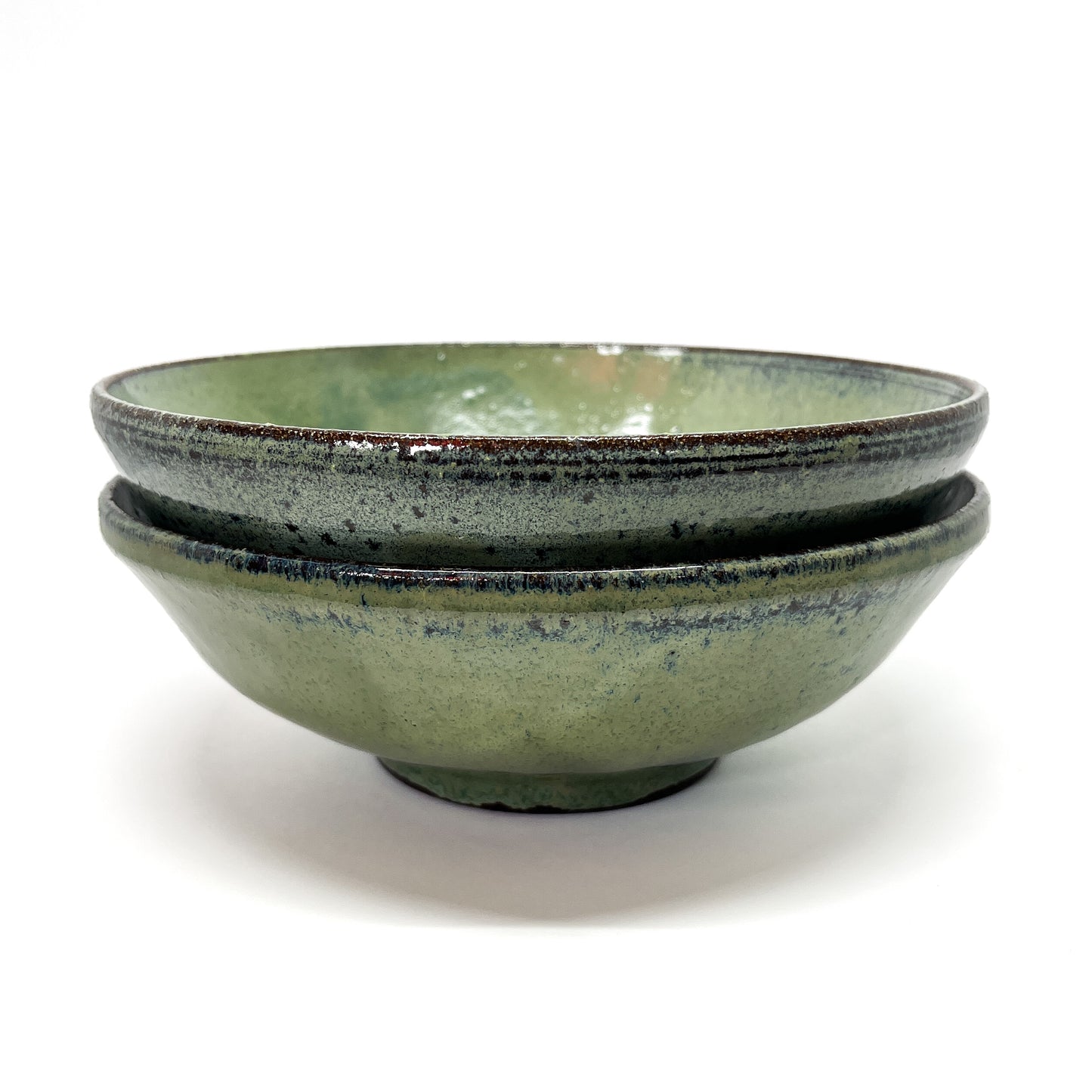 Two green bowls stacked on a white background.