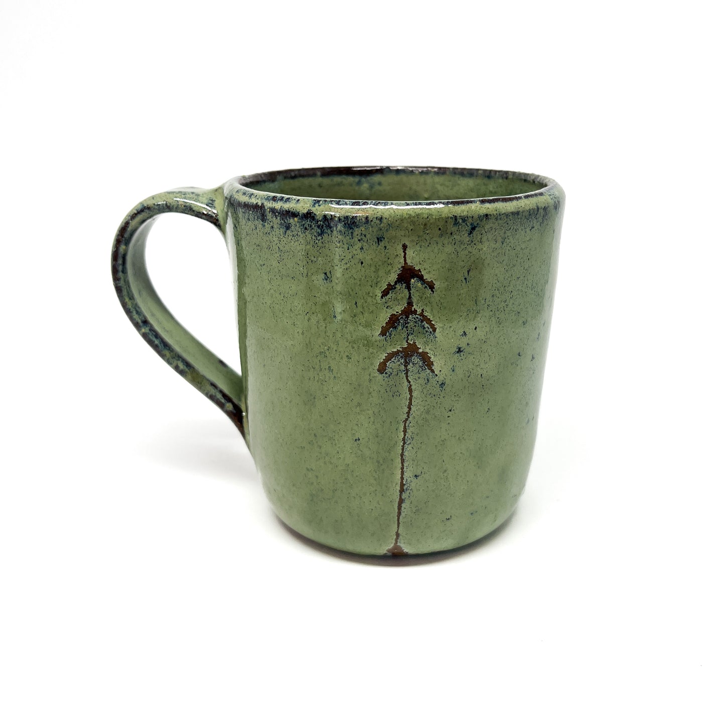 One green ceramic mugs with tree design.
