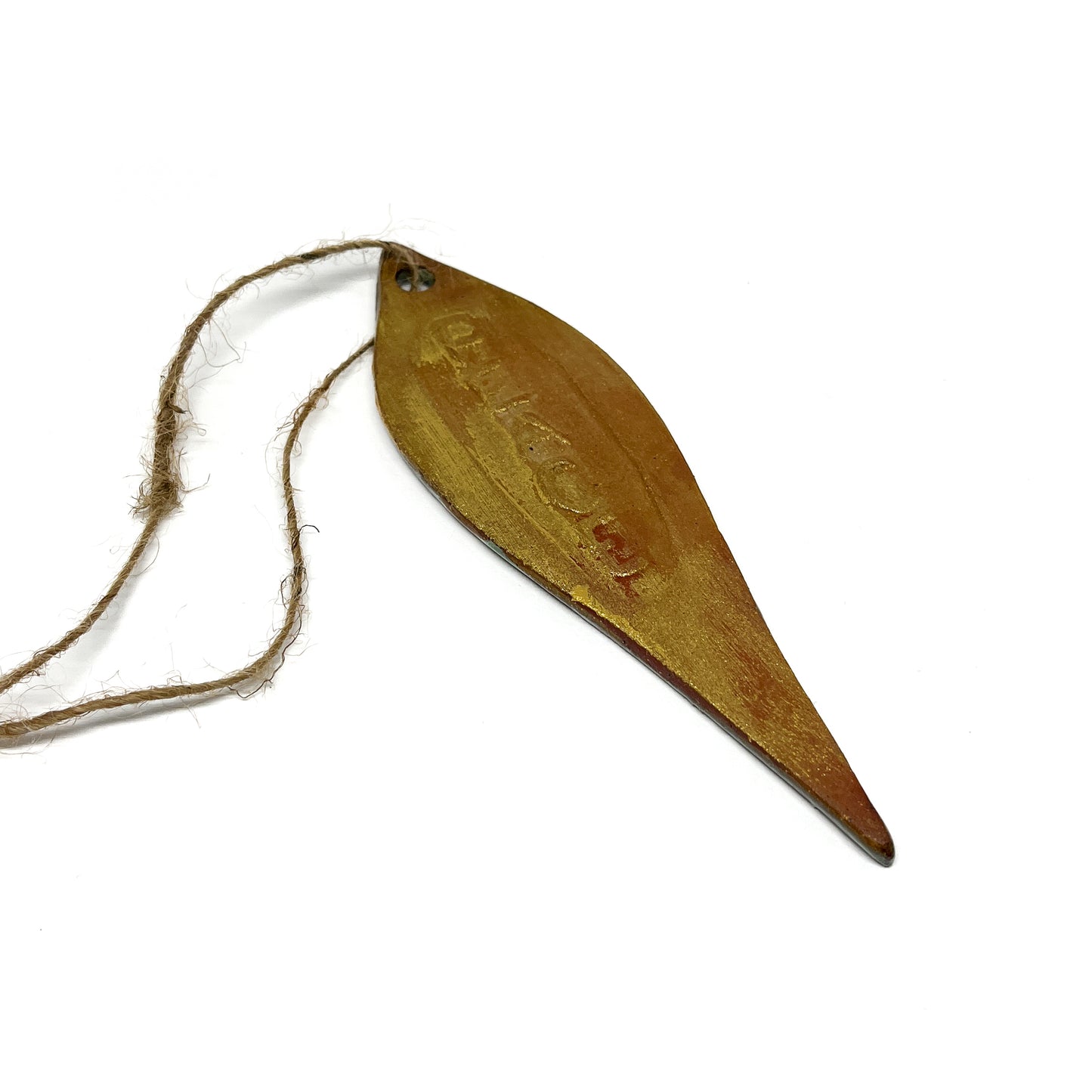 Brown leaf-shaped ornament with twine, angled view.