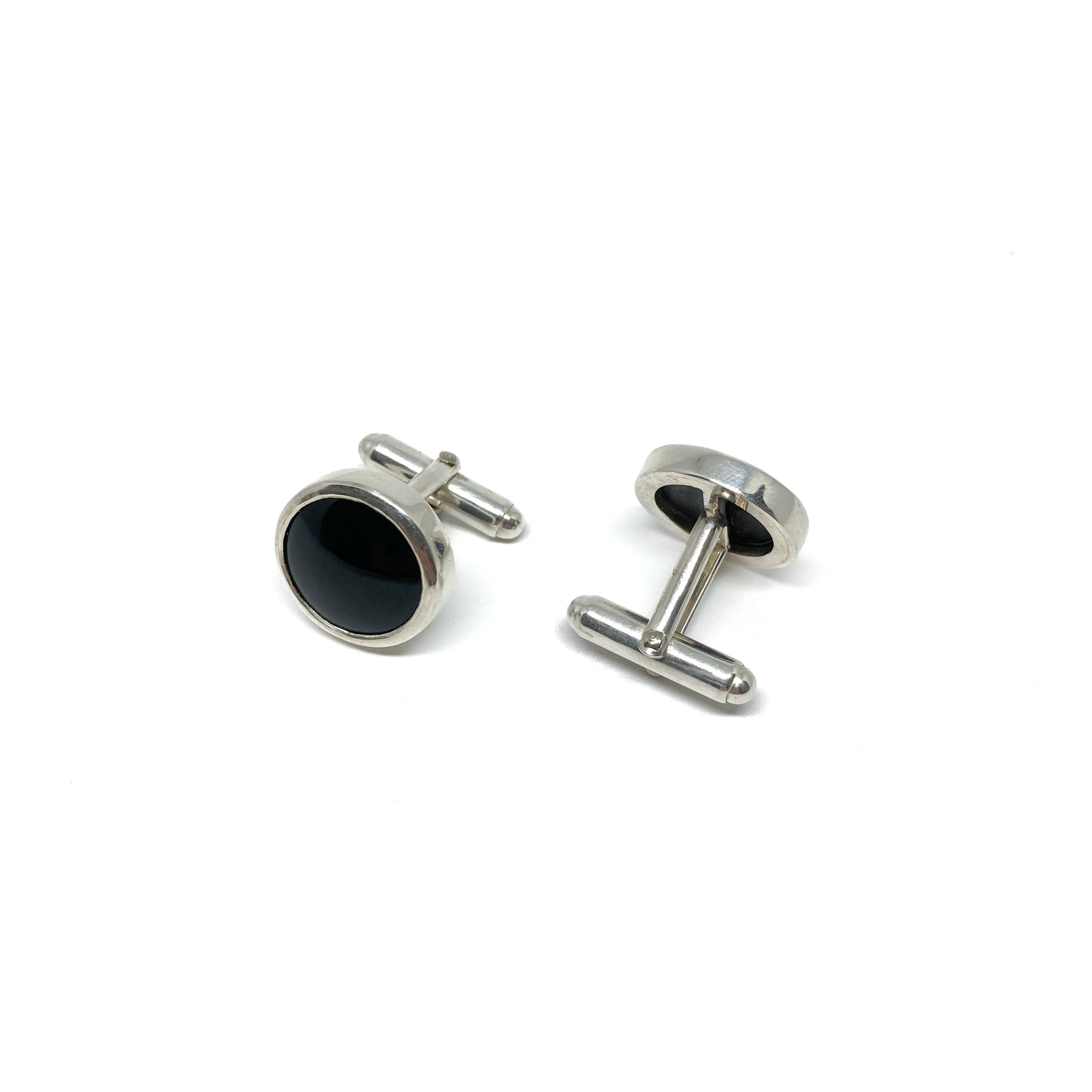 Pair of silver cufflinks with round, polished black onyx gemstones and toggle closures.