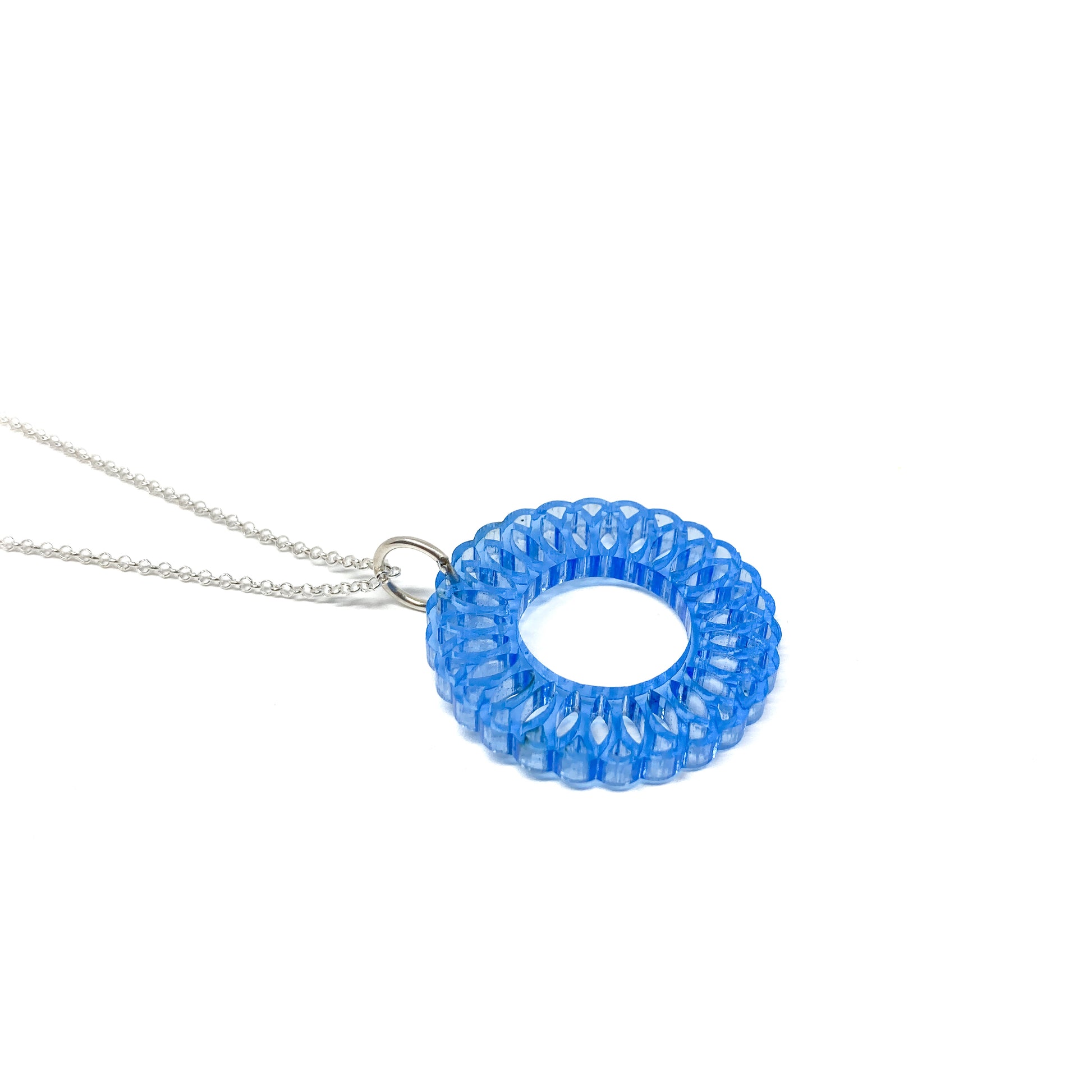 A silver chain necklace featuring a translucent blue circular mandala pendant with an intricate, layered geometric design and a central open circle.
