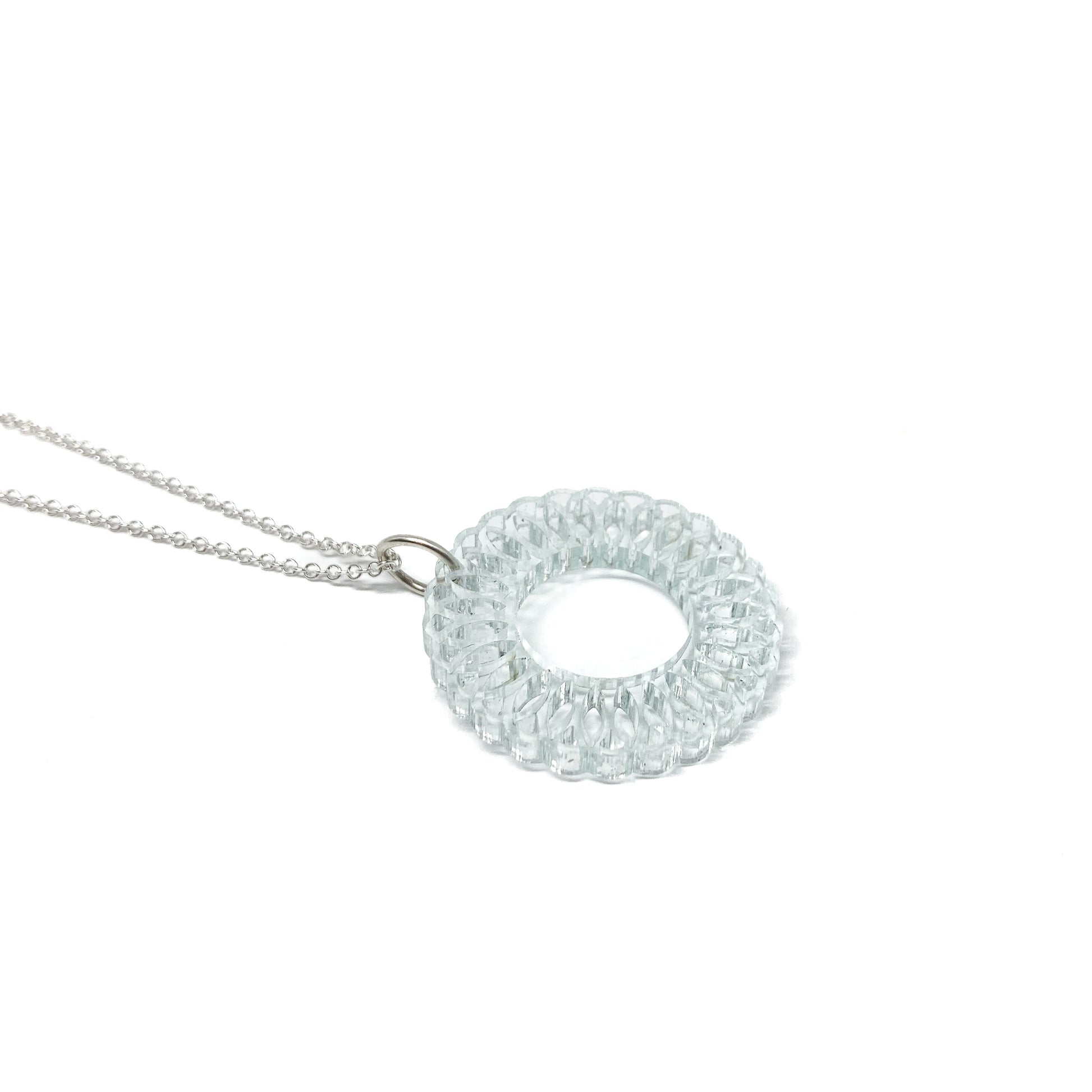 A silver chain necklace featuring a translucent light blue circular pendant with an intricate, layered geometric design and a central open circle.