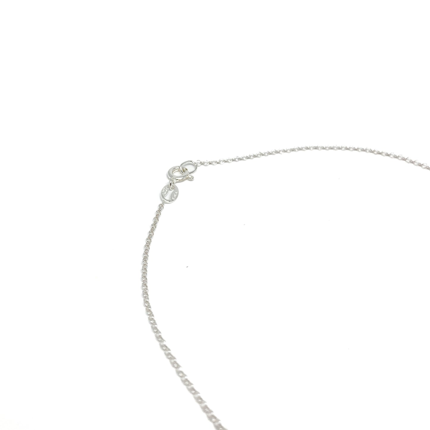 A close-up of the silver toggle clasp and delicate chain of a necklace, showing the fastening mechanism.