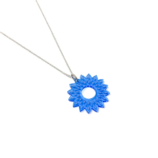 A silver chain necklace featuring a translucent blue mandala pendant with a floral, geometric design and a central open circle.