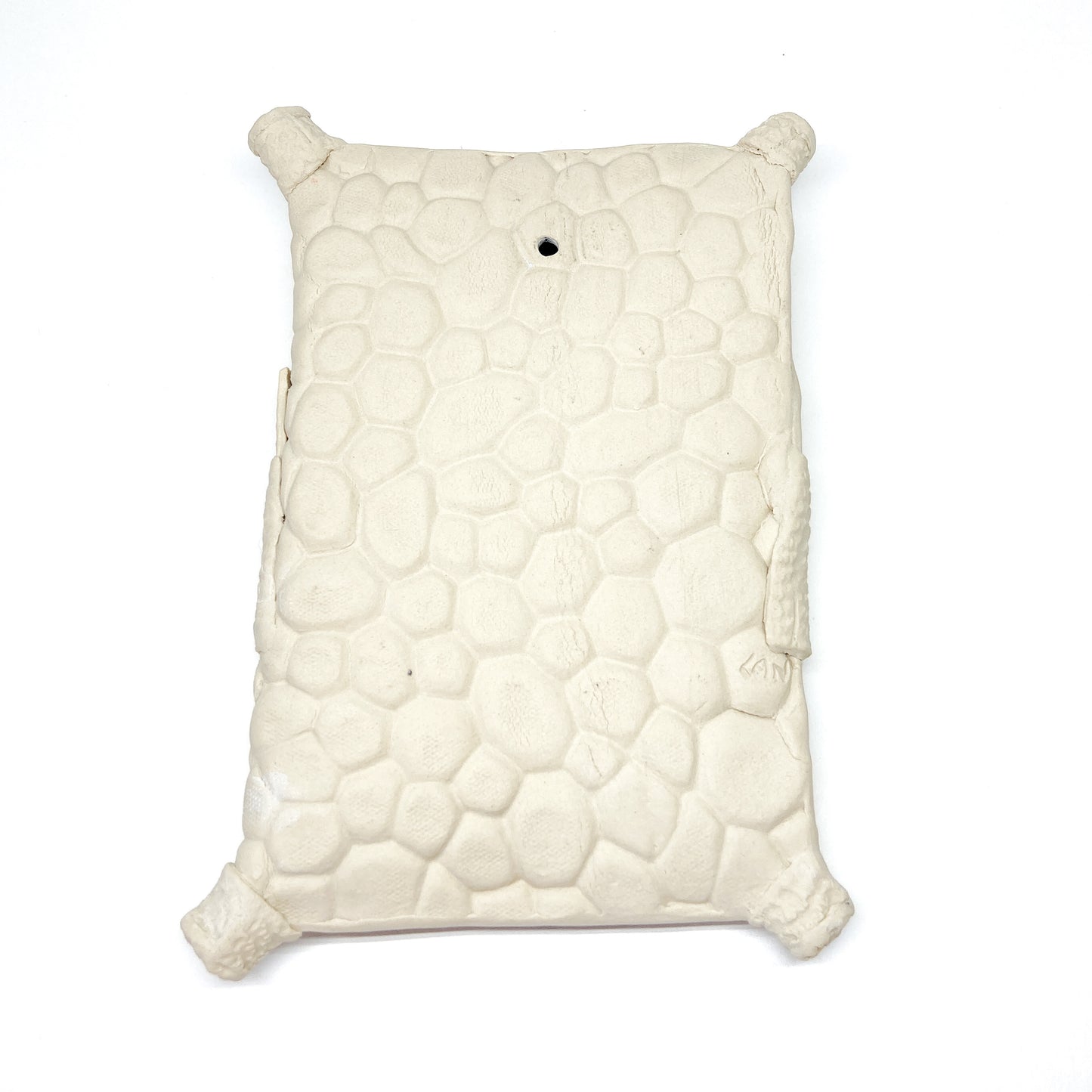 Textured, pillow-shaped wall sculpture with rounded corners and a hole in the upper top.