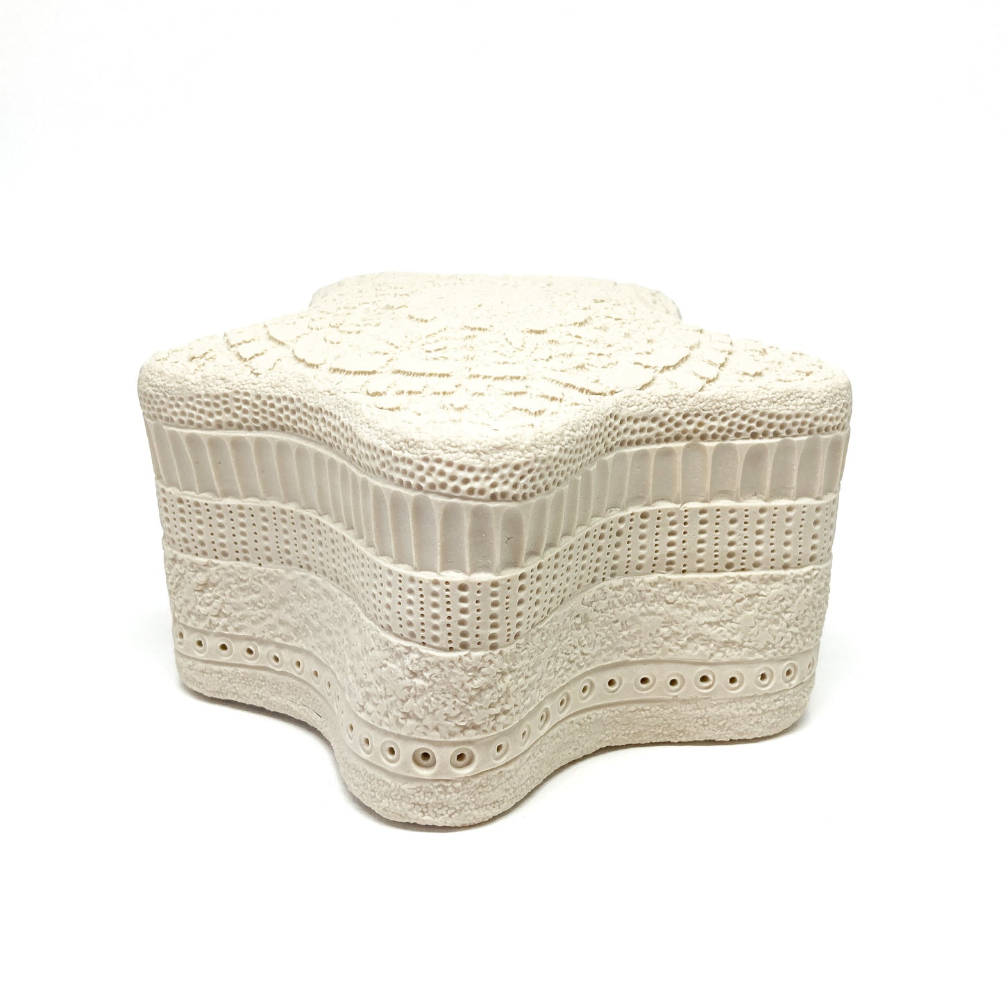 Textured star sculpture with layered, repeating surface patterns.